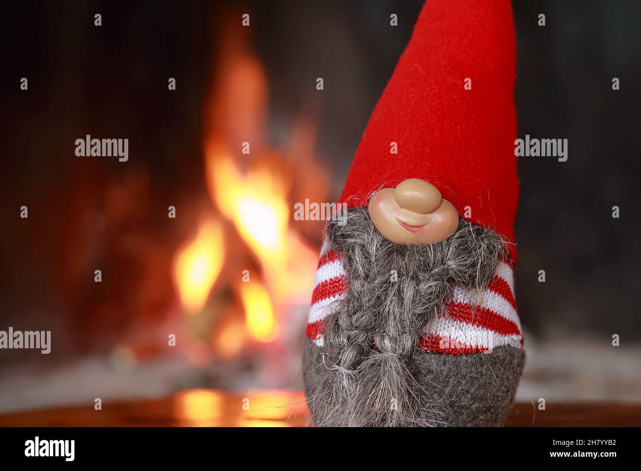 Lustige weihnachtsgnome mit brennenden Kamin im Hintergrund Stockfoto