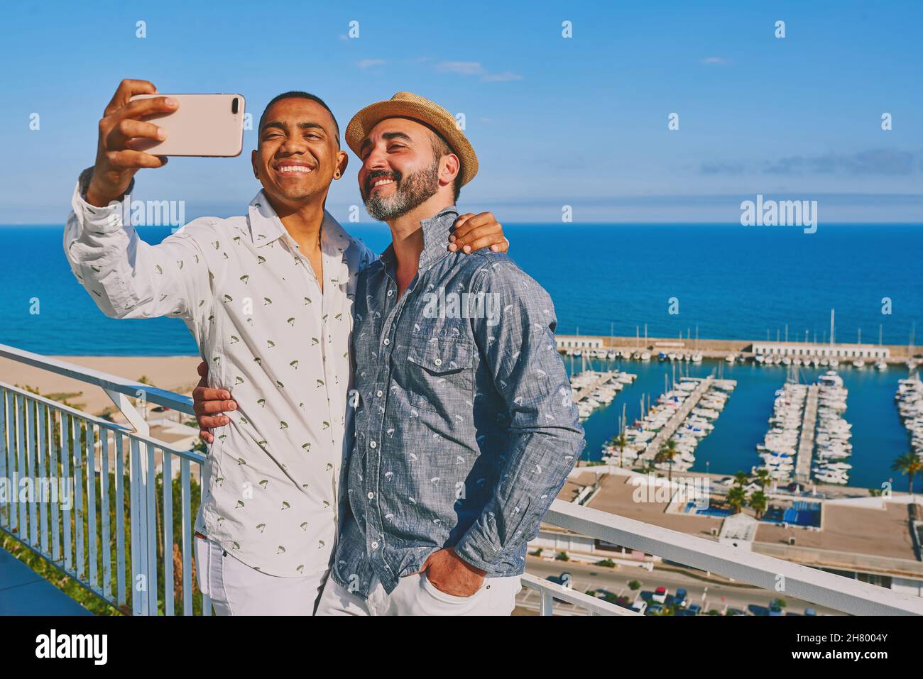 Ein schwules Paar, das ein Mobiltelefon benutzt Stockfoto