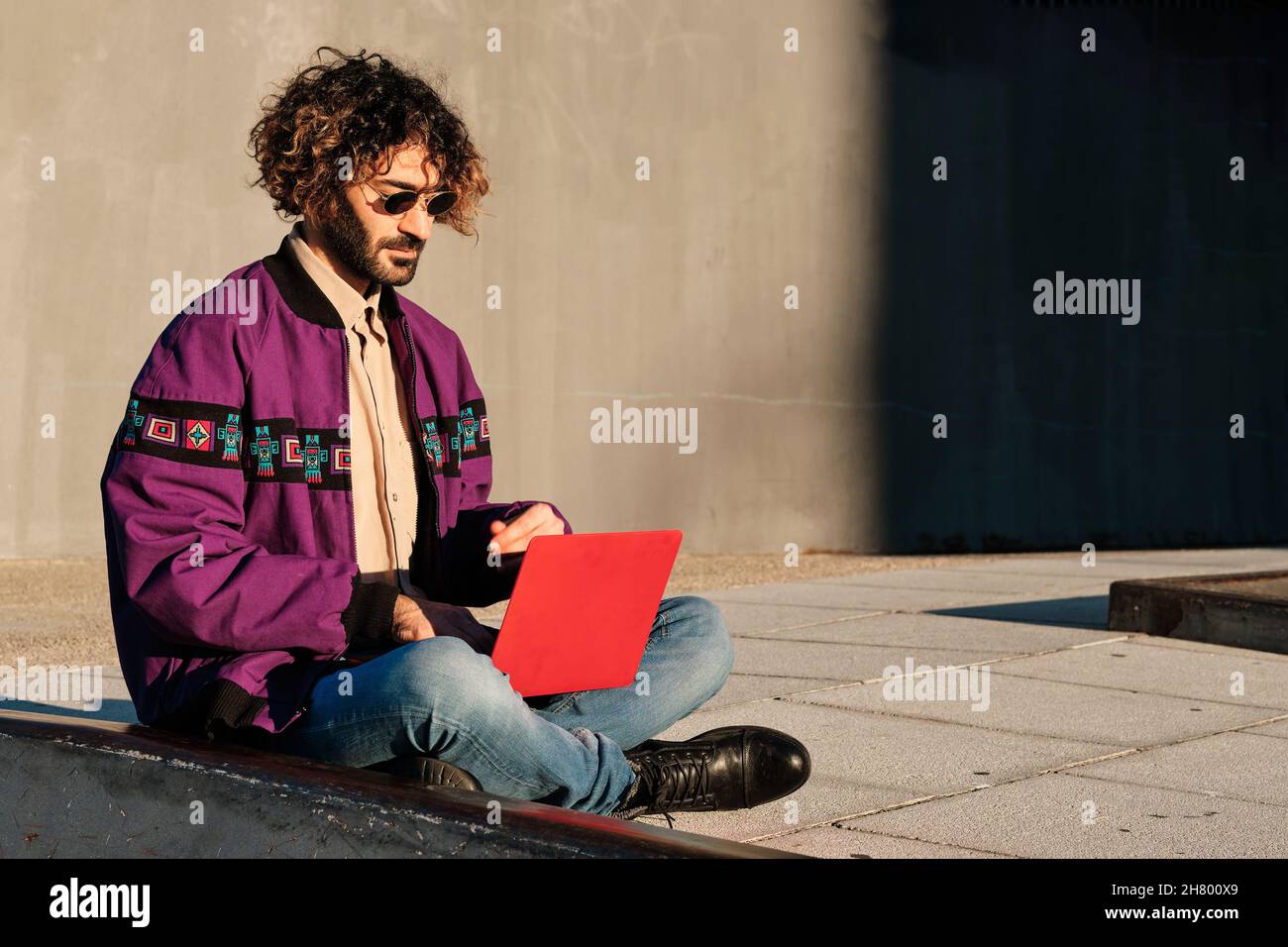 Mann mit einem Laptop, während er im Freien sitzt. Stockfoto