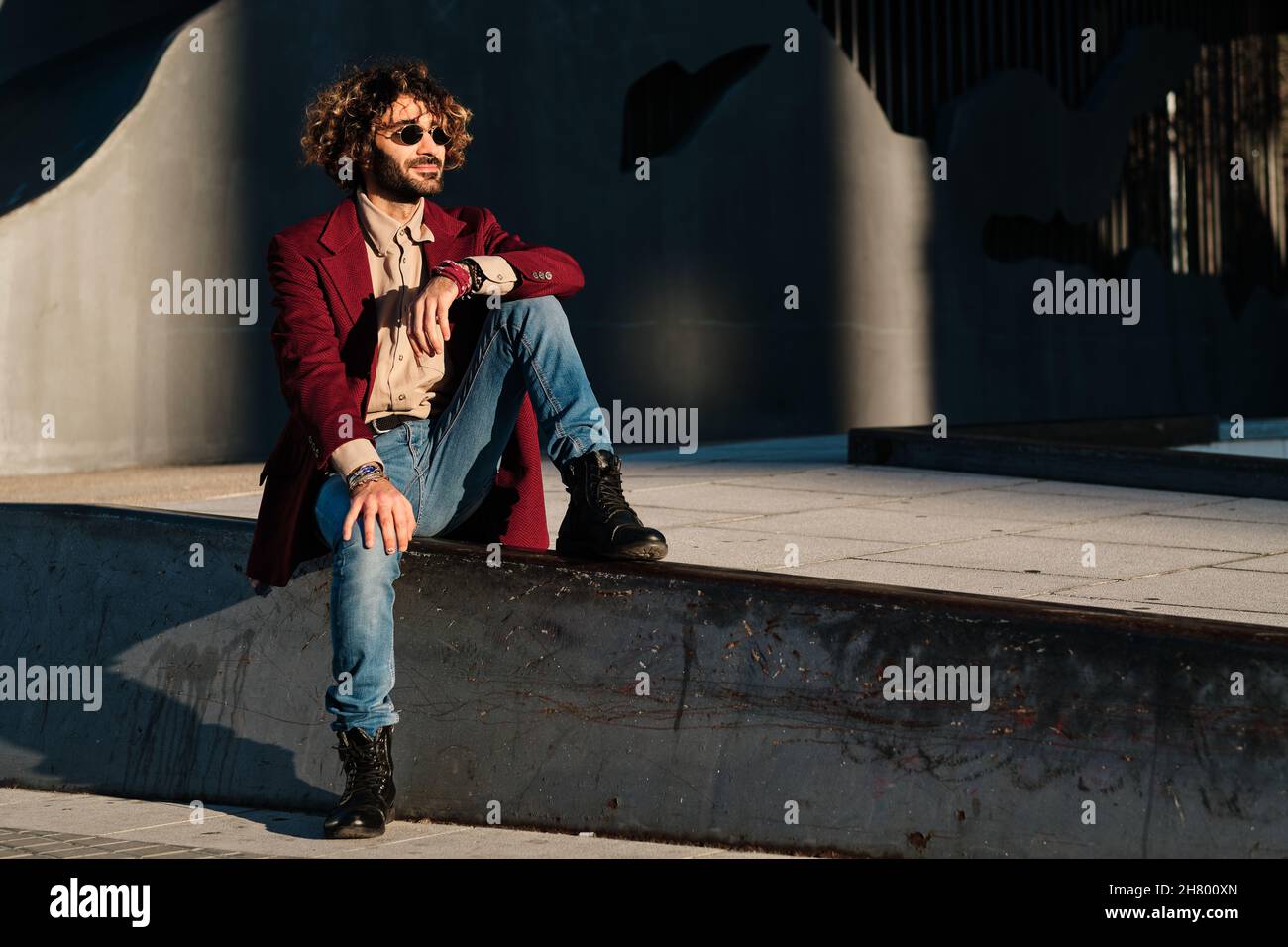 Hipster Mann gekleidet stilvoll sitzen im Freien. Stockfoto