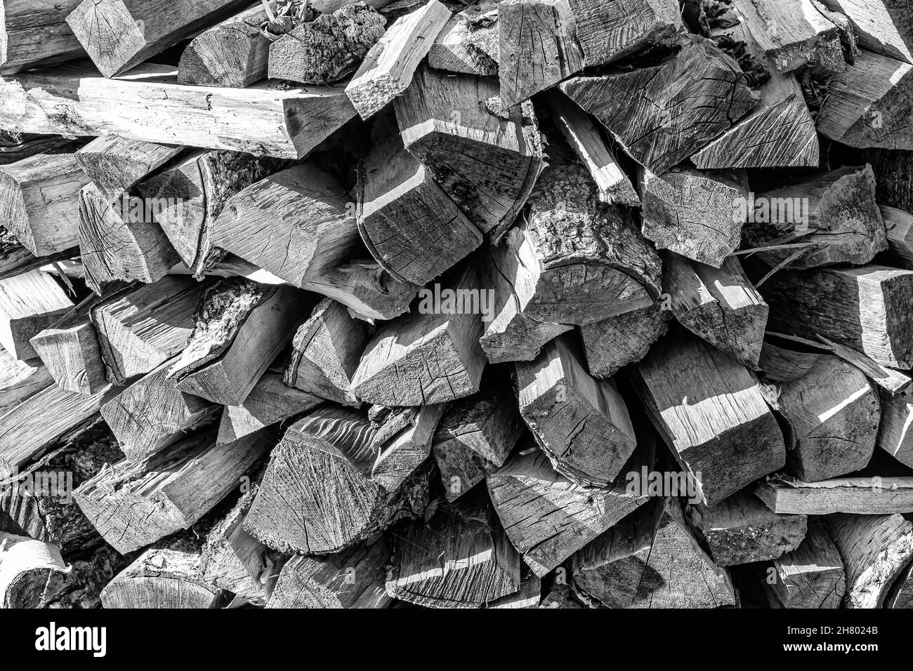 Schwarz-weißer Hintergrund des Haufenbrennholzstapels aus natürlichem Holz. Stockfoto