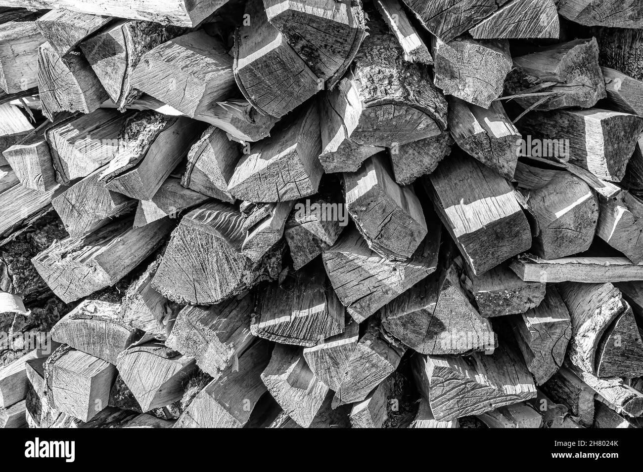 Schwarz-weißer Hintergrund des Haufenbrennholzstapels aus natürlichem Holz. Stockfoto