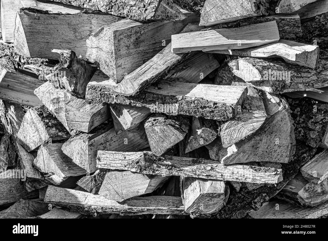 Schwarz-weißer Hintergrund des Haufenbrennholzstapels aus natürlichem Holz. Stockfoto