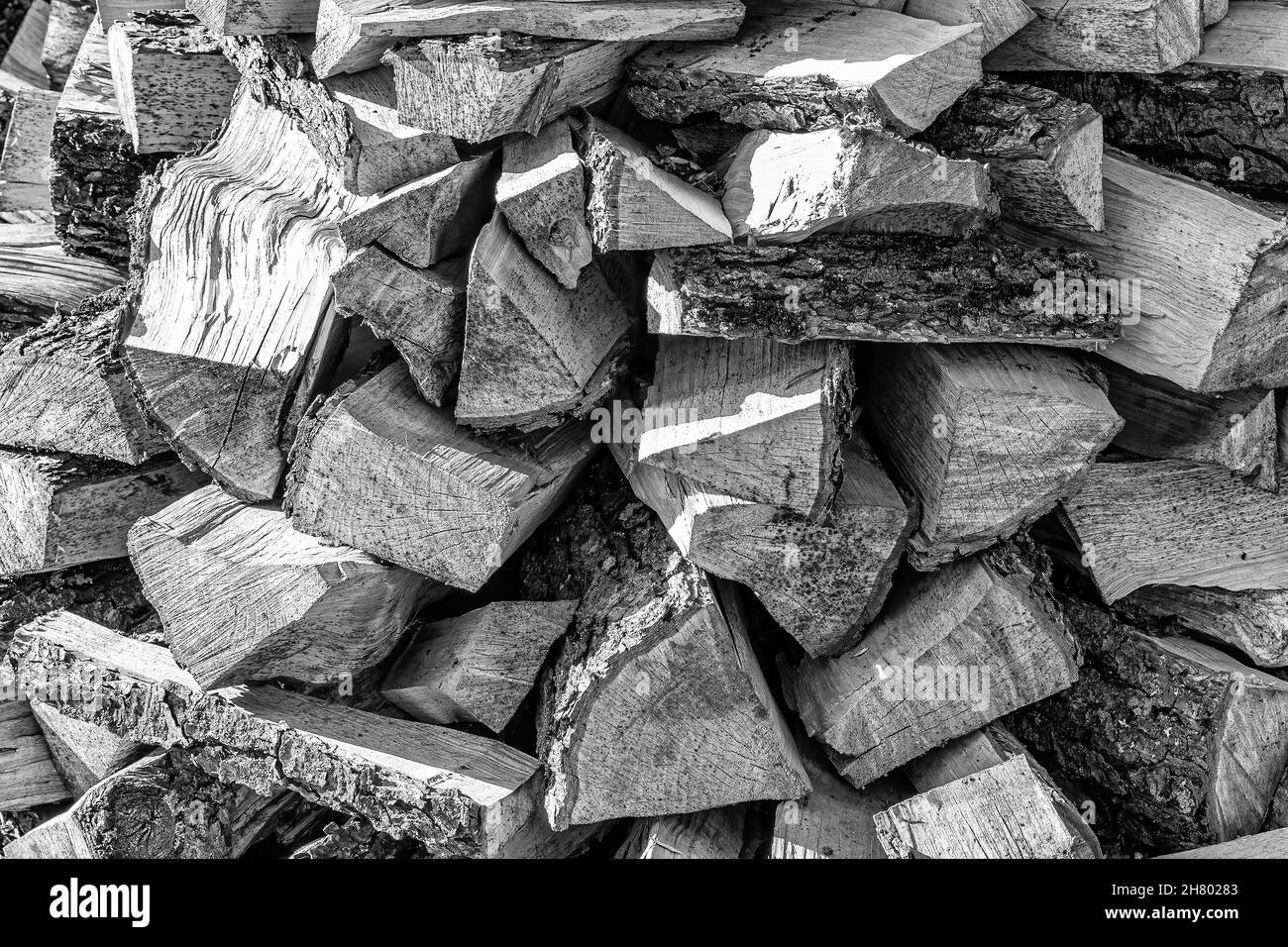 Schwarz-weißer Hintergrund des Haufenbrennholzstapels aus natürlichem Holz. Stockfoto