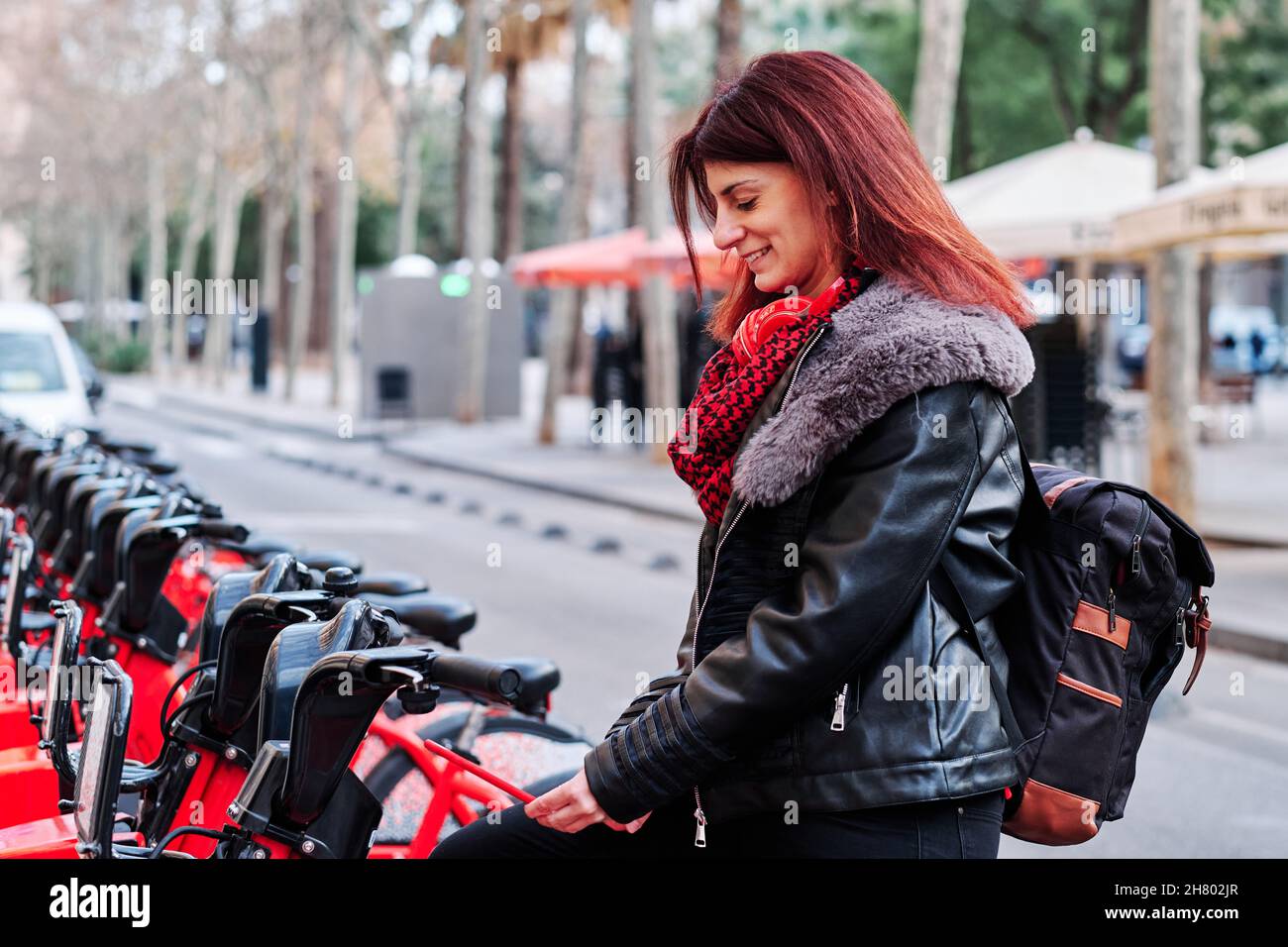 Frau auf dem öffentlichen Parkplatz der Leihfahrräder. Stockfoto