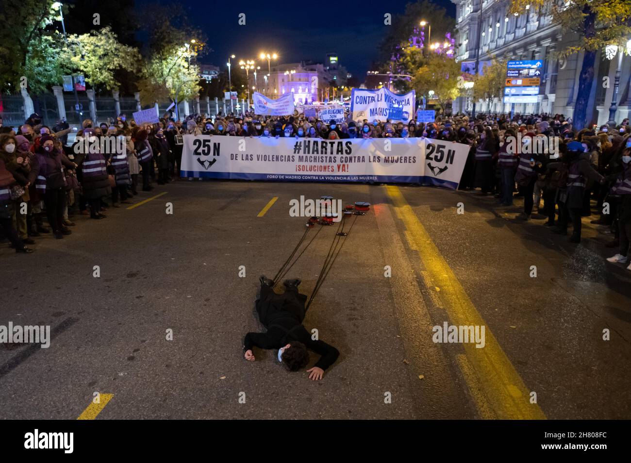 Madrid, Spanien. 25th. November 2021. Während einer Demonstration zum Internationalen Tag zur Beseitigung der Gewalt gegen Frauen liegt eine Frau auf Flor, gebunden an Kochtöpfe. Quelle: Marcos del Mazo/Alamy Live News Stockfoto