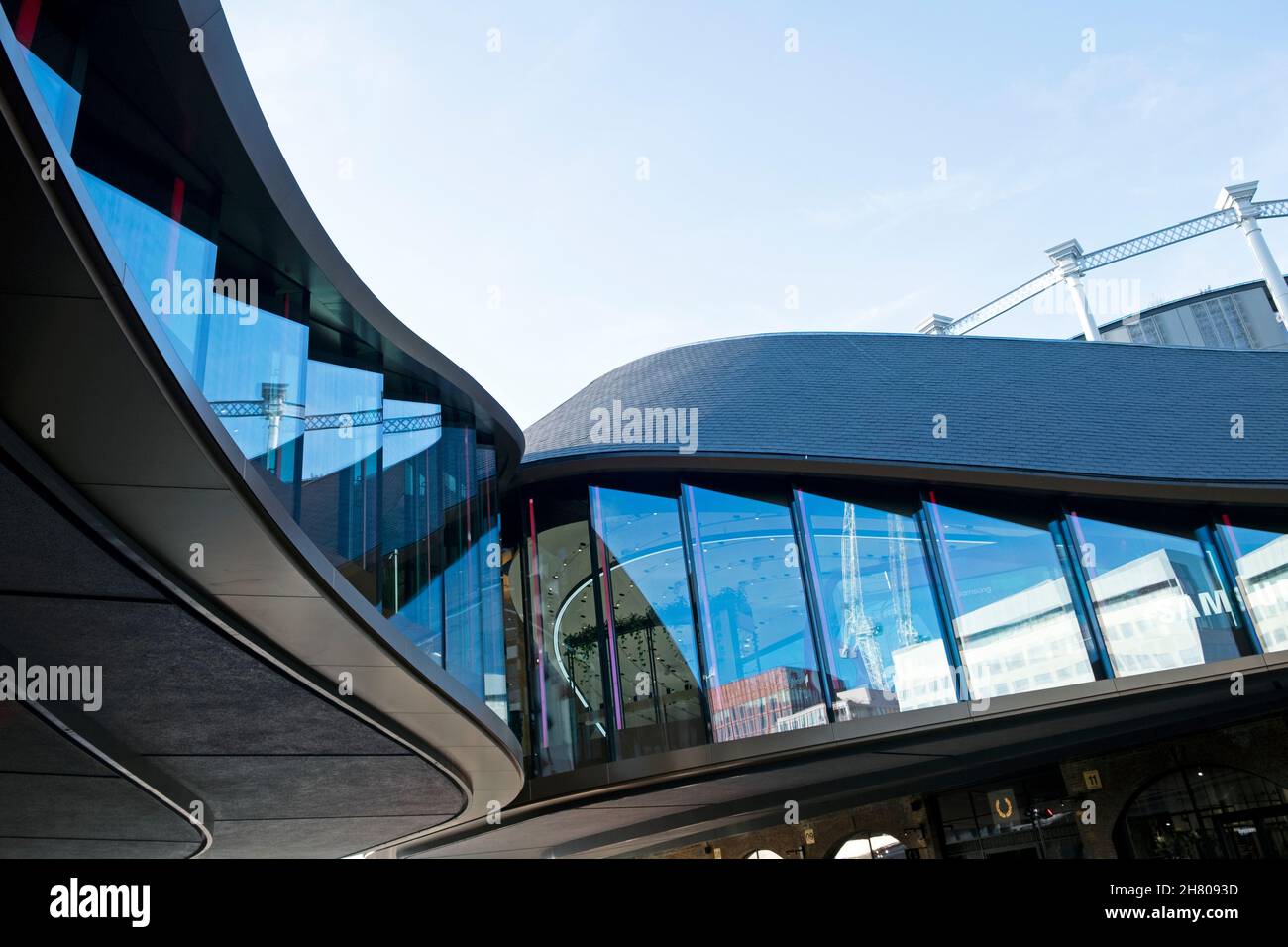 Blick auf die Details der geschwungenen Kurve im Dach und den Fenstern im Außenbereich der Coal Drops Yard Shopping Center-Architektur in Kings Cross Reentwicklung London UK Stockfoto