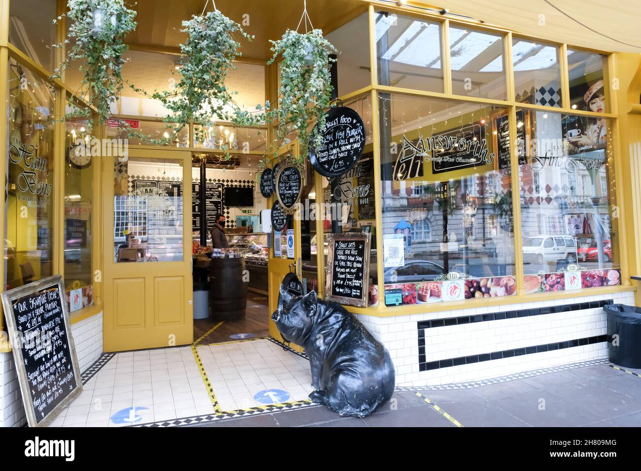 Außenansicht einer Metzgerei in der walisischen Küstenstadt Llandudno. Draußen sitzt ein lustiges Modell-Riesenschwein. Stockfoto