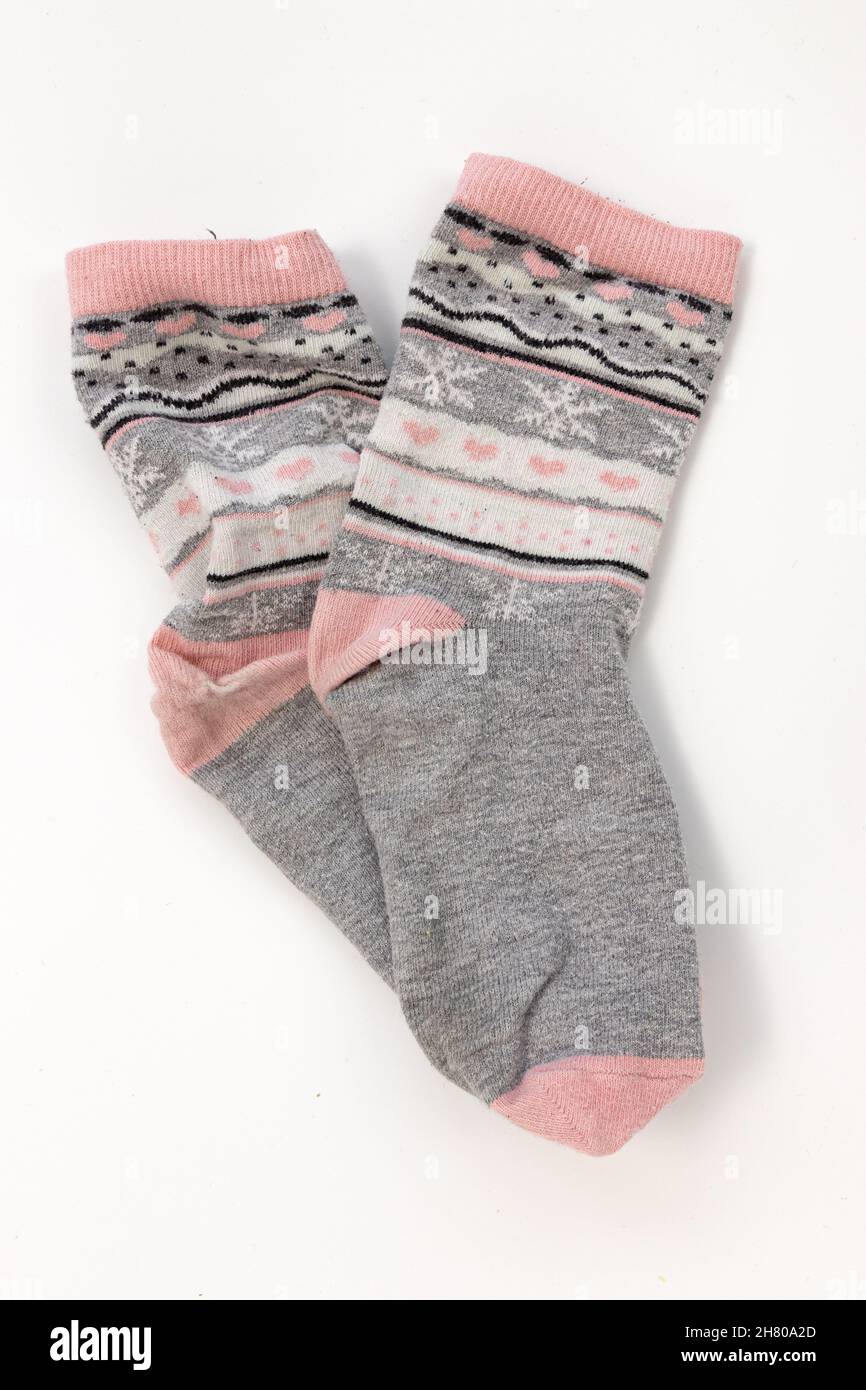 Kombinieren Sie schmutzige graue Socken isoliert auf weißem Hintergrund, Socken mit Ornamenten Stockfoto