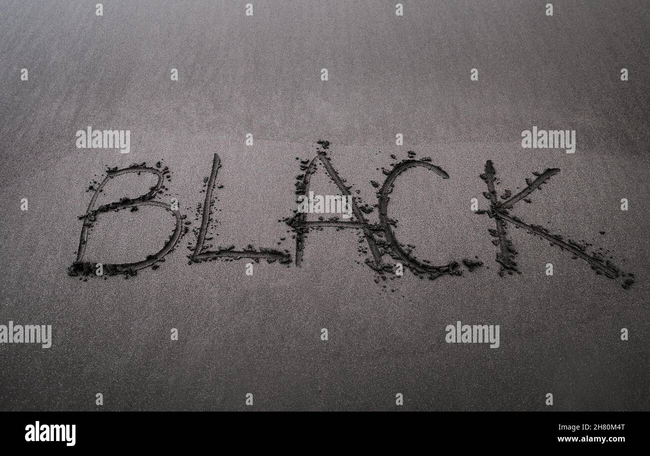 SCHWARZES Wort handschriftliche Inschrift auf dem schwarzen Sand Madeira Strand als Black Friday Verkaufskonzept. Stockfoto
