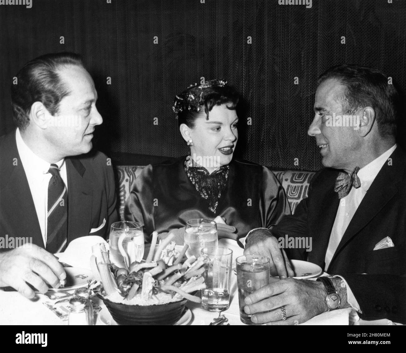 JUDY GARLAND und ihr 3rd-Mann SID LUFT mit HUMPHREY BOGART im Romanoff's Restaurant in Los Angeles, Kalifornien, 1955 Stockfoto