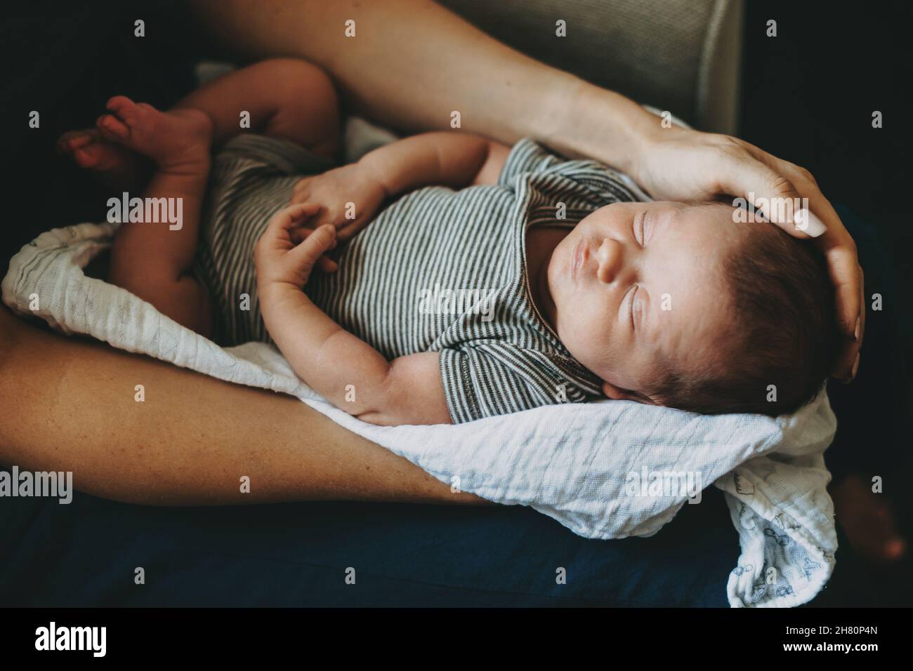 Neugeborenes schläft auf den Händen der Mutter. Draufsicht. Frau mit Kleinkind. Stockfoto