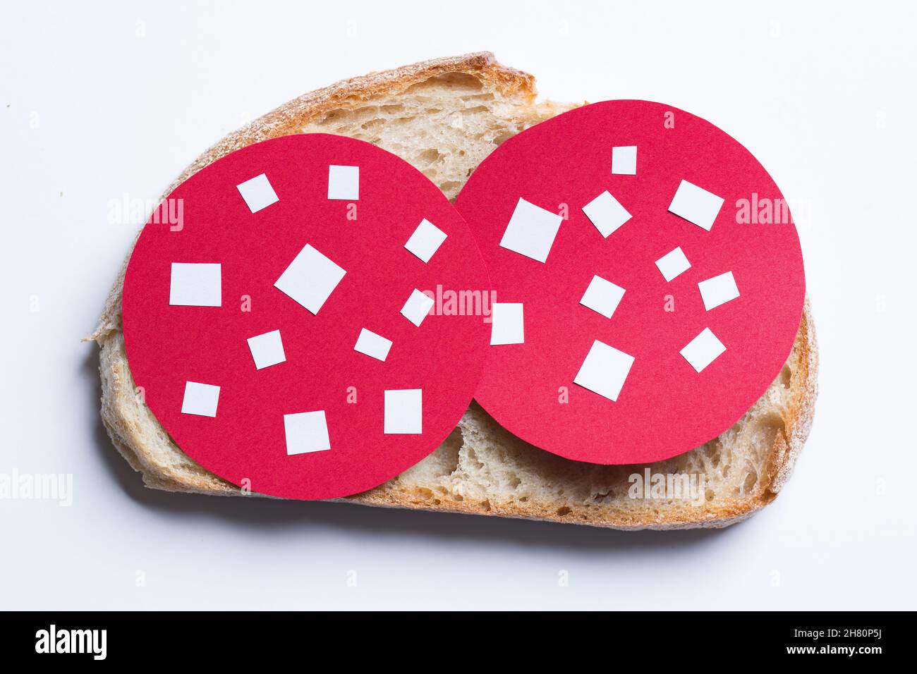 Die Brotscheibe mit dem Papier schneiden Salami aus. Stockfoto