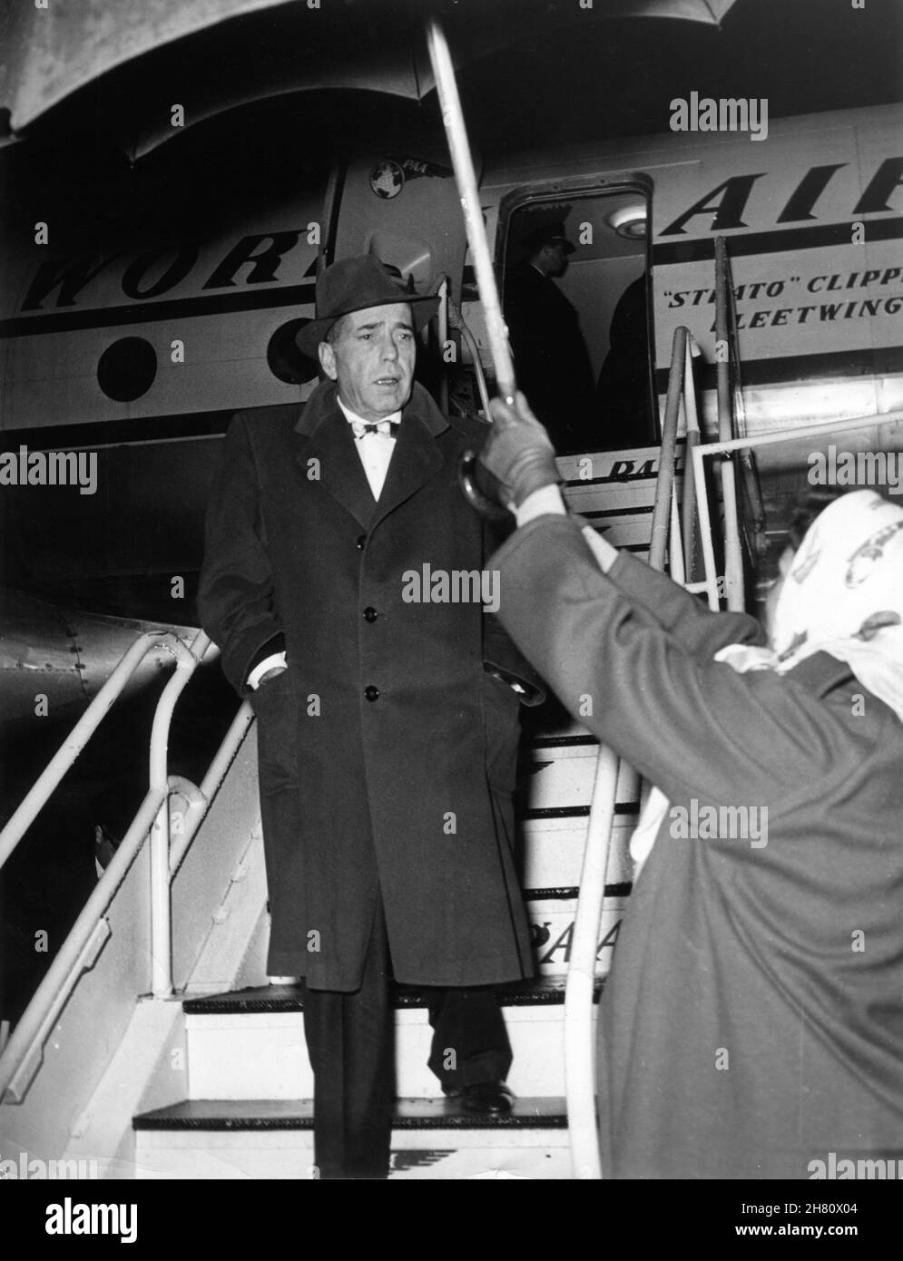 HUMPHREY BOGART, der im Januar 1954 mit einem T.W.A.-Flugzeug auf dem Internationalen Flughafen Rom, Italien, anreist, um die BARFUSS-CONTESSA mit Ava Gardner für den Regisseur und Schriftsteller Joseph L. Mankiewicz zu drehen Stockfoto