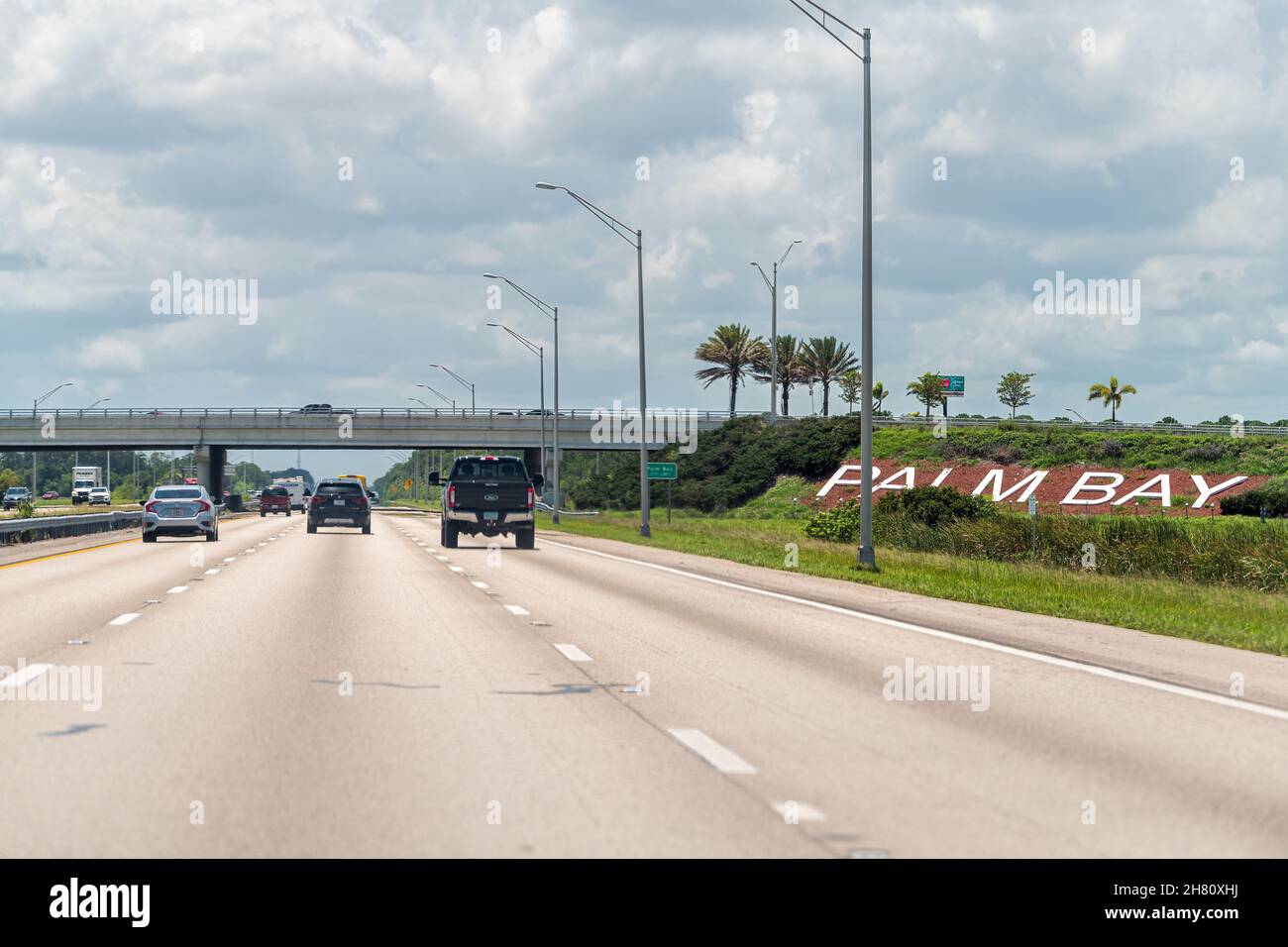 Palm Bay, USA - 8. Juli 2021: Interstate Highway 95 Straße mit Verkehrswagen an sonnigen Tag in Brevard County, Florida mit Brücke Überführung Ausfahrt und Stadt Stockfoto