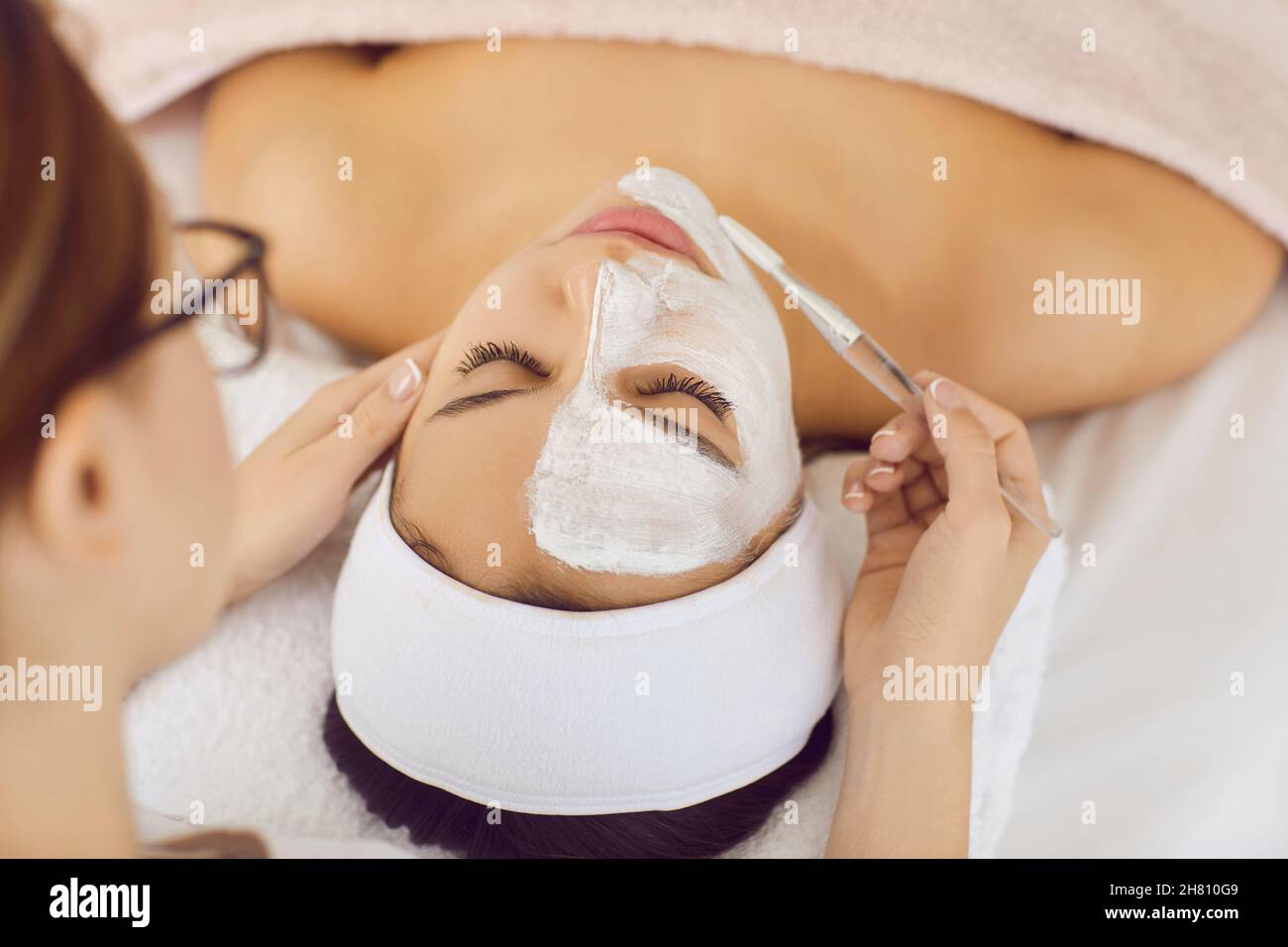 Kosmetologe tun Gesichtsmaske für Frau Client Stockfoto