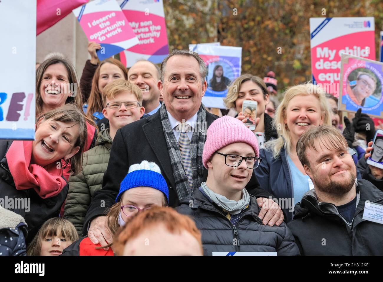 Westminster, London, Großbritannien, 26th. November 2021. Dr. Liam Fox, ehemaliger Staatssekretär für Verteidigung, feiert gemeinsam mit Aktivisten der National Down Syndrom Policy Group die erste Hürde im Parlament. Aktivisten außerhalb des Parlaments unterstützen den von Liam Fox eingeführten Down-Syndrom-Gesetzentwurf, der heute im Parlament seine Lesung aus dem Jahr 2nd hat und heute, nachdem die Regierung ihre Unterstützung für die Gesetzesüberstellung angekündigt hatte, diese Hürde beseitigen sollte. Der Gesetzentwurf soll neue Leitlinien für öffentliche Einrichtungen festlegen, um die Bedürfnisse von Menschen mit Down-Syndrom besser zu erfüllen. Stockfoto