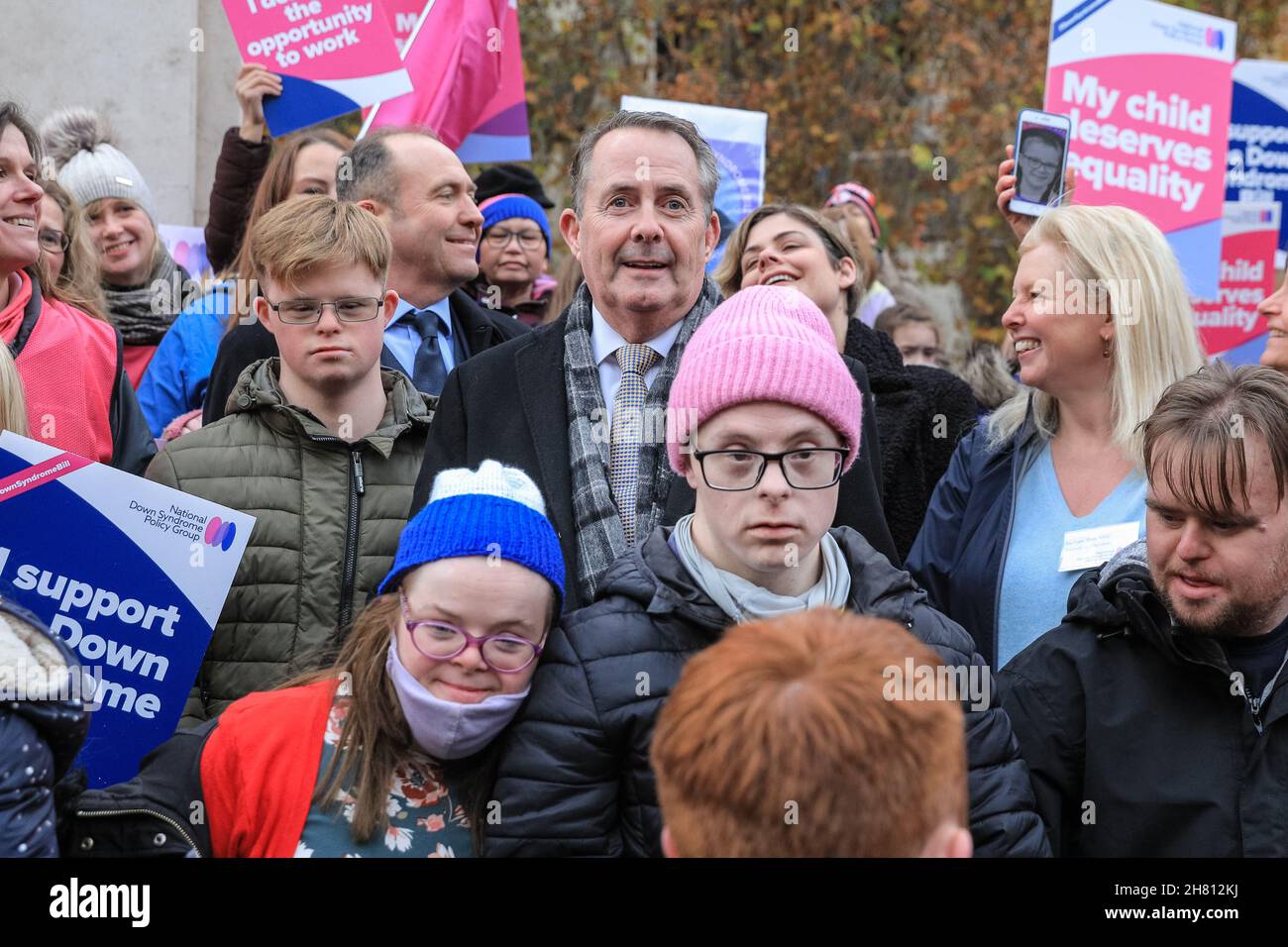 Westminster, London, Großbritannien, 26th. November 2021. Dr. Liam Fox, ehemaliger Staatssekretär für Verteidigung, feiert gemeinsam mit Aktivisten der National Down Syndrom Policy Group die erste Hürde im Parlament. Aktivisten außerhalb des Parlaments unterstützen den von Liam Fox eingeführten Down-Syndrom-Gesetzentwurf, der heute im Parlament seine Lesung aus dem Jahr 2nd hat und heute, nachdem die Regierung ihre Unterstützung für die Gesetzesüberstellung angekündigt hatte, diese Hürde beseitigen sollte. Der Gesetzentwurf soll neue Leitlinien für öffentliche Einrichtungen festlegen, um die Bedürfnisse von Menschen mit Down-Syndrom besser zu erfüllen. Stockfoto