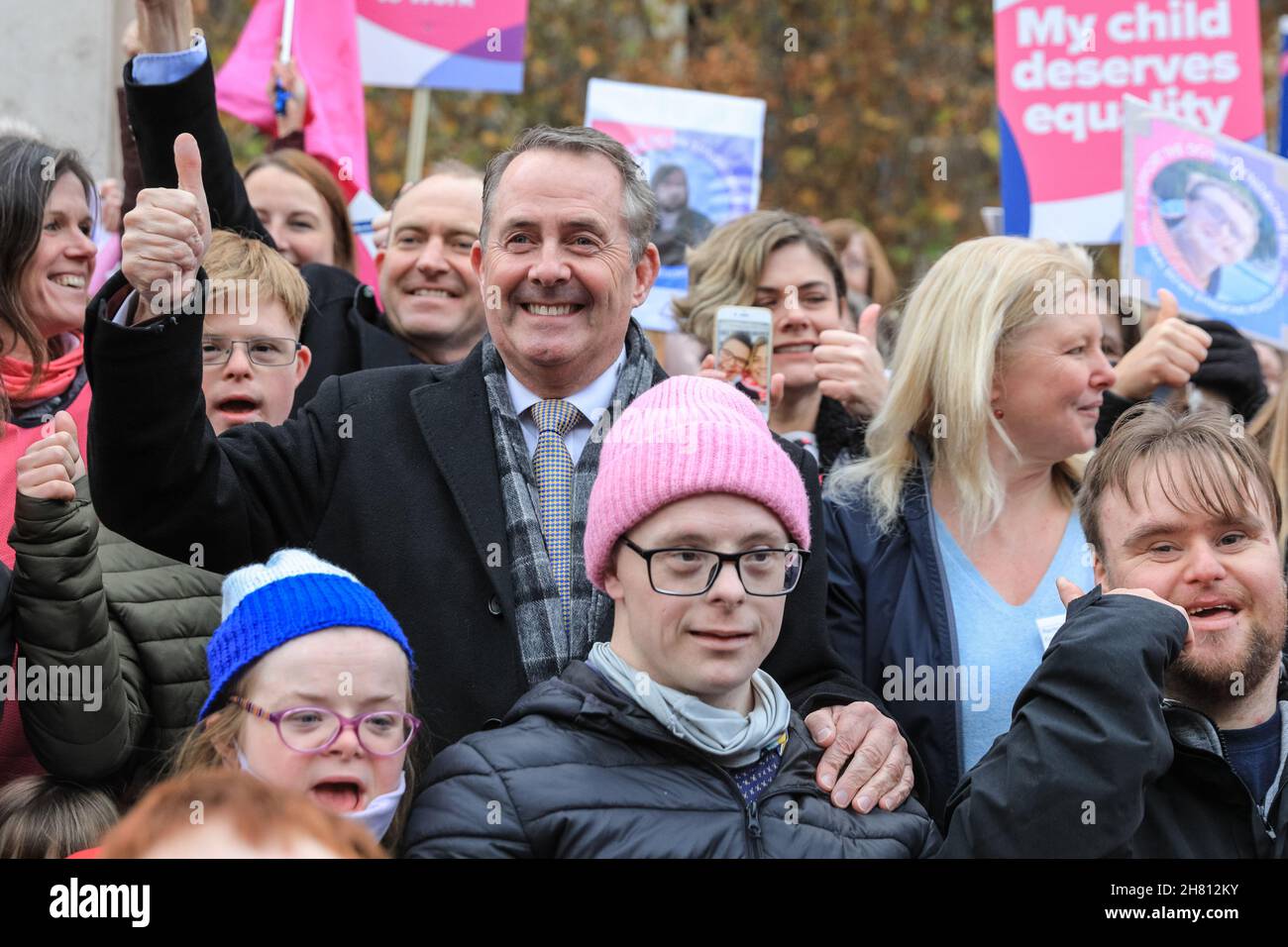 Westminster, London, Großbritannien, 26th. November 2021. Dr. Liam Fox, ehemaliger Staatssekretär für Verteidigung, feiert gemeinsam mit Aktivisten der National Down Syndrom Policy Group die erste Hürde im Parlament. Aktivisten außerhalb des Parlaments unterstützen den von Liam Fox eingeführten Down-Syndrom-Gesetzentwurf, der heute im Parlament seine Lesung aus dem Jahr 2nd hat und heute, nachdem die Regierung ihre Unterstützung für die Gesetzesüberstellung angekündigt hatte, diese Hürde beseitigen sollte. Der Gesetzentwurf soll neue Leitlinien für öffentliche Einrichtungen festlegen, um die Bedürfnisse von Menschen mit Down-Syndrom besser zu erfüllen. Stockfoto