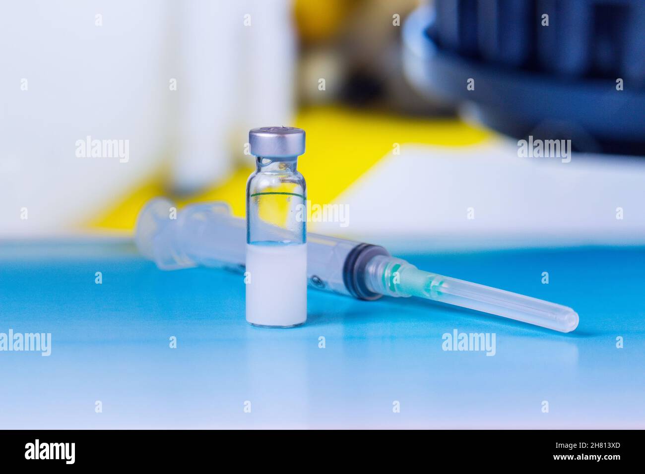 Fläschchen mit Medizin und Spritze auf Labortisch Stockfoto