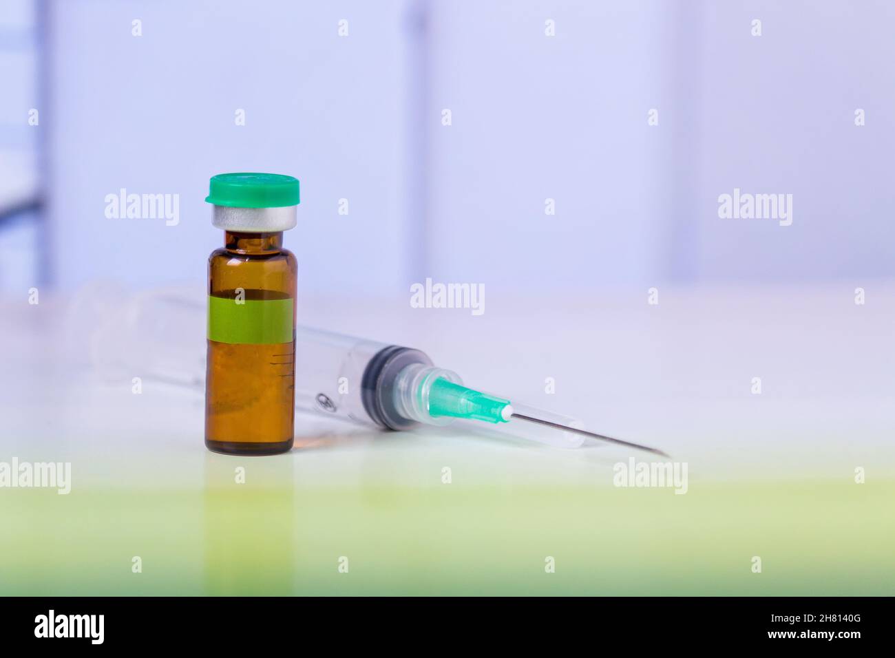 Fläschchen mit Medizin und Spritze auf Labortisch Stockfoto