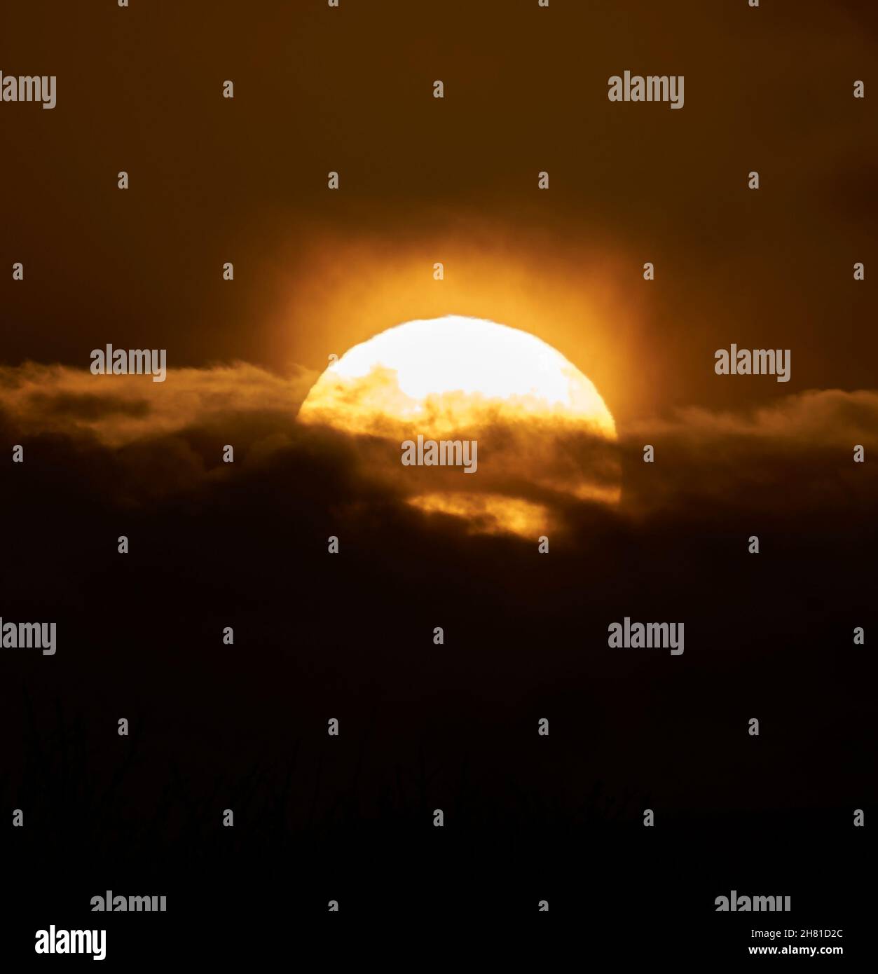 Teleaufnahme eines atemberaubenden Sonnenuntergangs mit dramatischen Wolken. November 2021 Glasgow, Schottland. Stockfoto