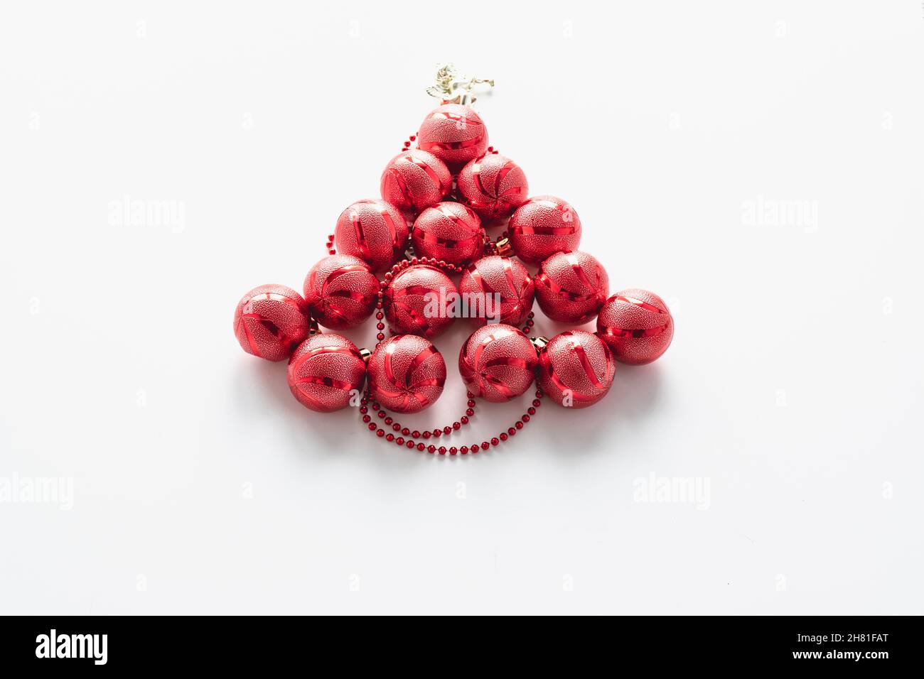 Weihnachtsbaum mit roten Weihnachtskugeln mit einem Engel und roten Perlen ausgekleidet. Festliche Postkarte. Horizontales Foto. Stockfoto