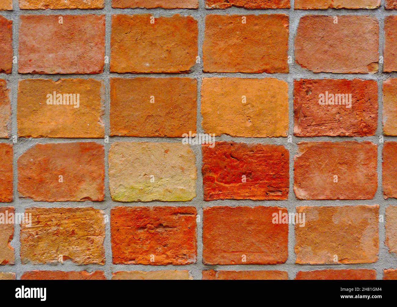Strukturierte rote braune Ziegelwand Nahaufnahme Detail. Graue Mörtelverbindung. Grobe Lehm-Textur. Running Bond-Muster. Bauindustrie und Architektur. Stockfoto