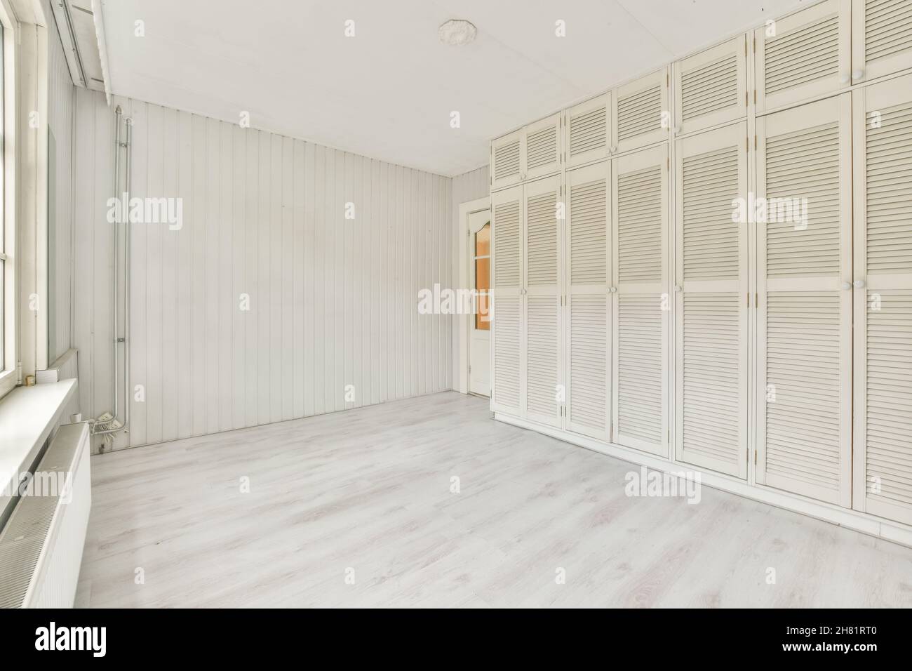 Geräumiges, helles Zimmer mit Wandschrank Stockfoto