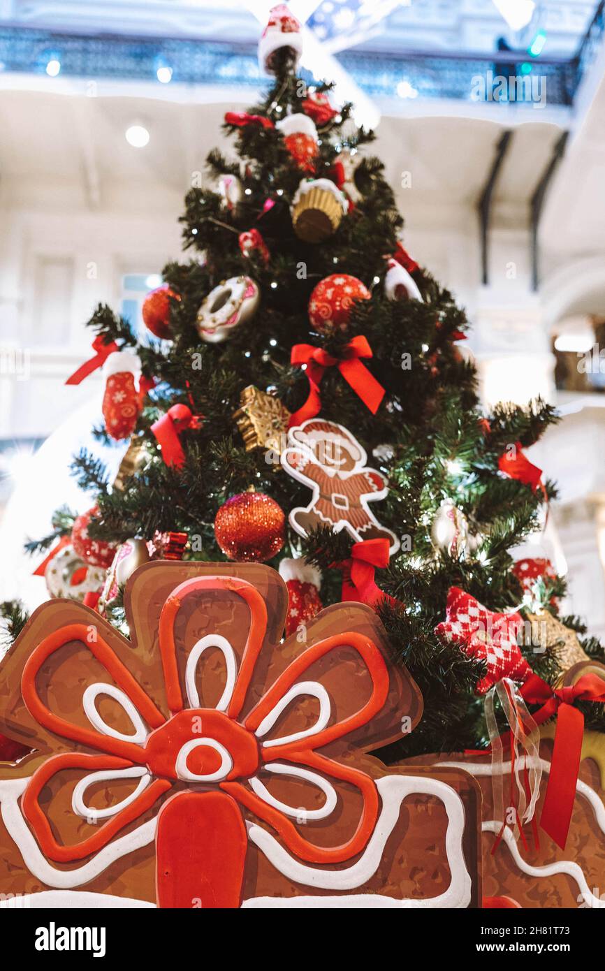 Weihnachtsbaum geschmückt mit Spielzeug und Geschenken. Rote Schleife, Ingwer, Weihnachtsball Stockfoto
