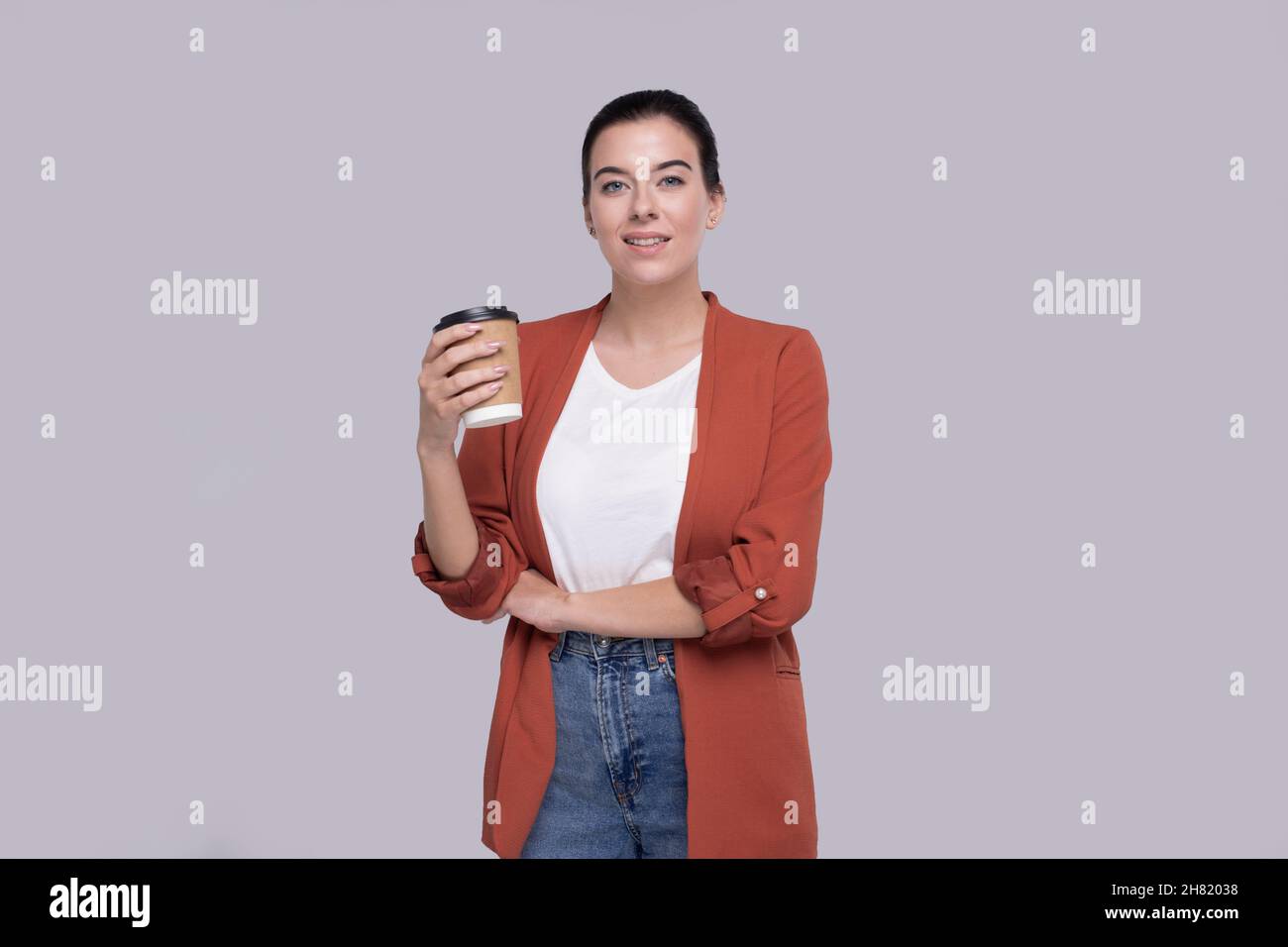 Mädchen Hält Kaffee Take Away Tasse. Mädchen mit To Go Kaffeetasse in Händen isoliert Stockfoto