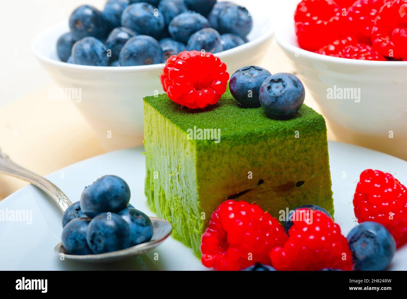 Grüner Tee Matcha Mousse Torte mit Himbeeren und Heidelbeeren an der Spitze Stockfoto