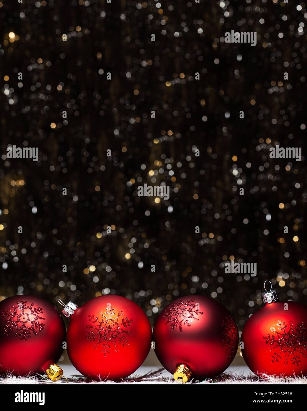 Weihnachtsschmuck Zusammensetzung der vier roten Abend Kugeln mit rot glitter Schneeflocken auf es auf dunklem Hintergrund mit Silber und Gold Farben boke Stockfoto