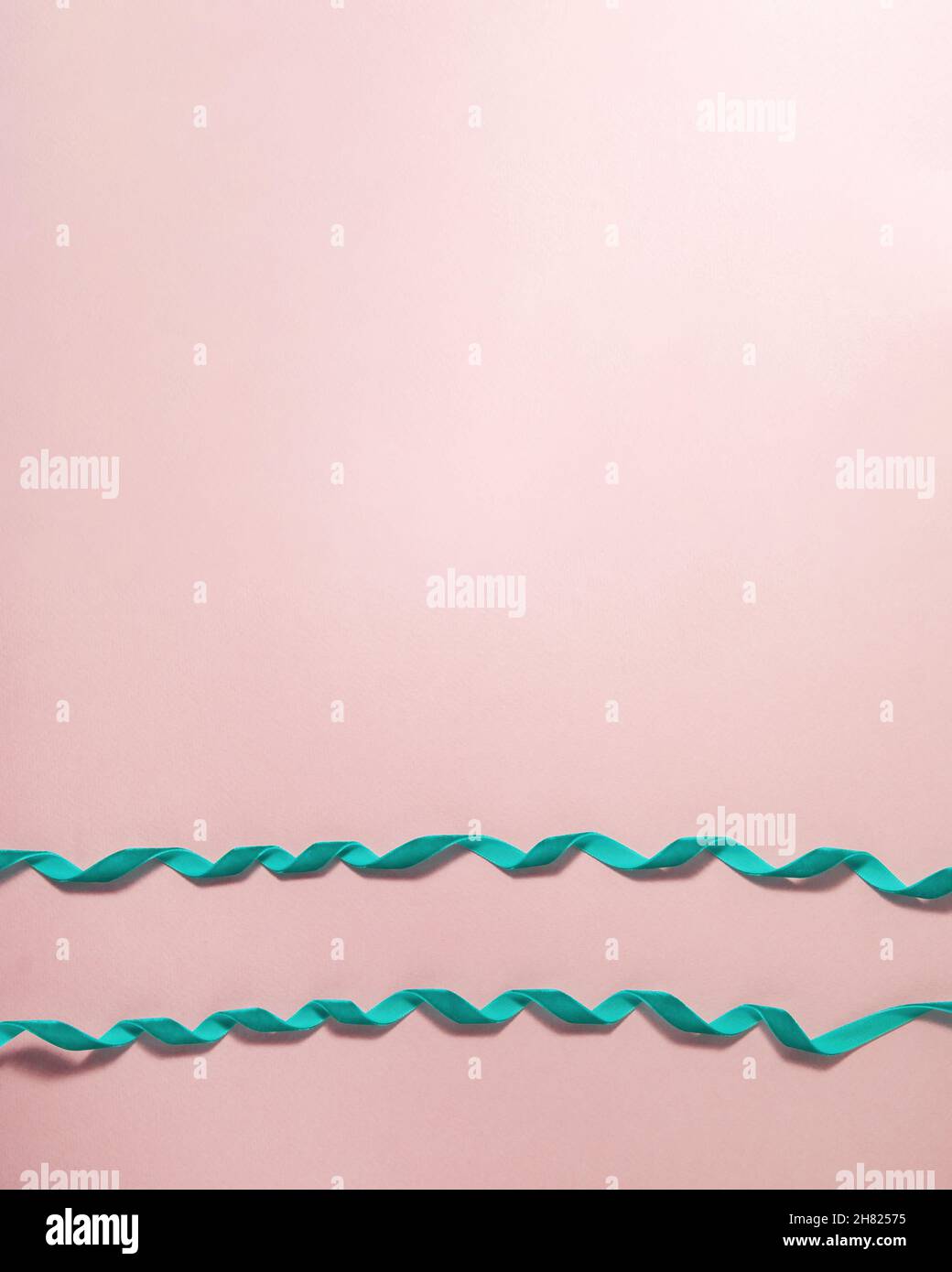 Cyan Samtband Schleife entlang des Rahmens auf rosa Hintergrund. Weihnachten Urlaub Mutter und Vater Valentinstag und Geburtstag Geschenk Wohnung Lay Konzept w Stockfoto