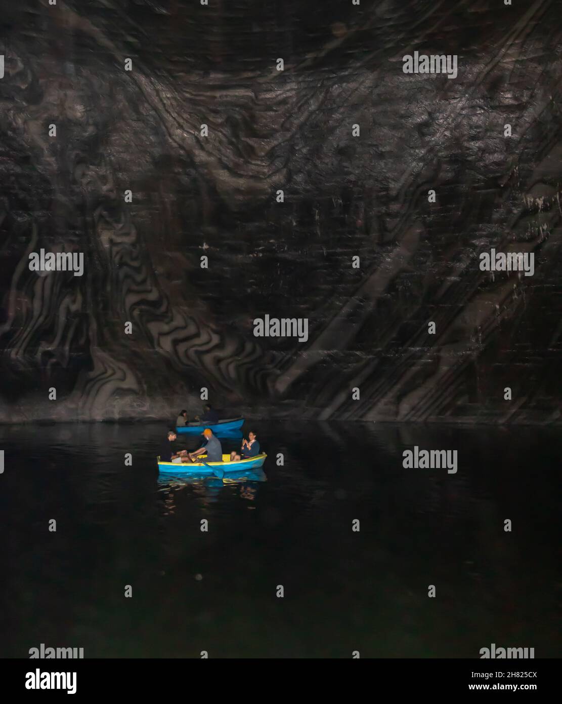 Turda, Rumänien-24. August 2021: Foto aus dem Inneren des Salzbergwerks von Turda, in dem Menschen in Booten auf dem See, umgeben von Salzwänden, zu sehen sind Stockfoto