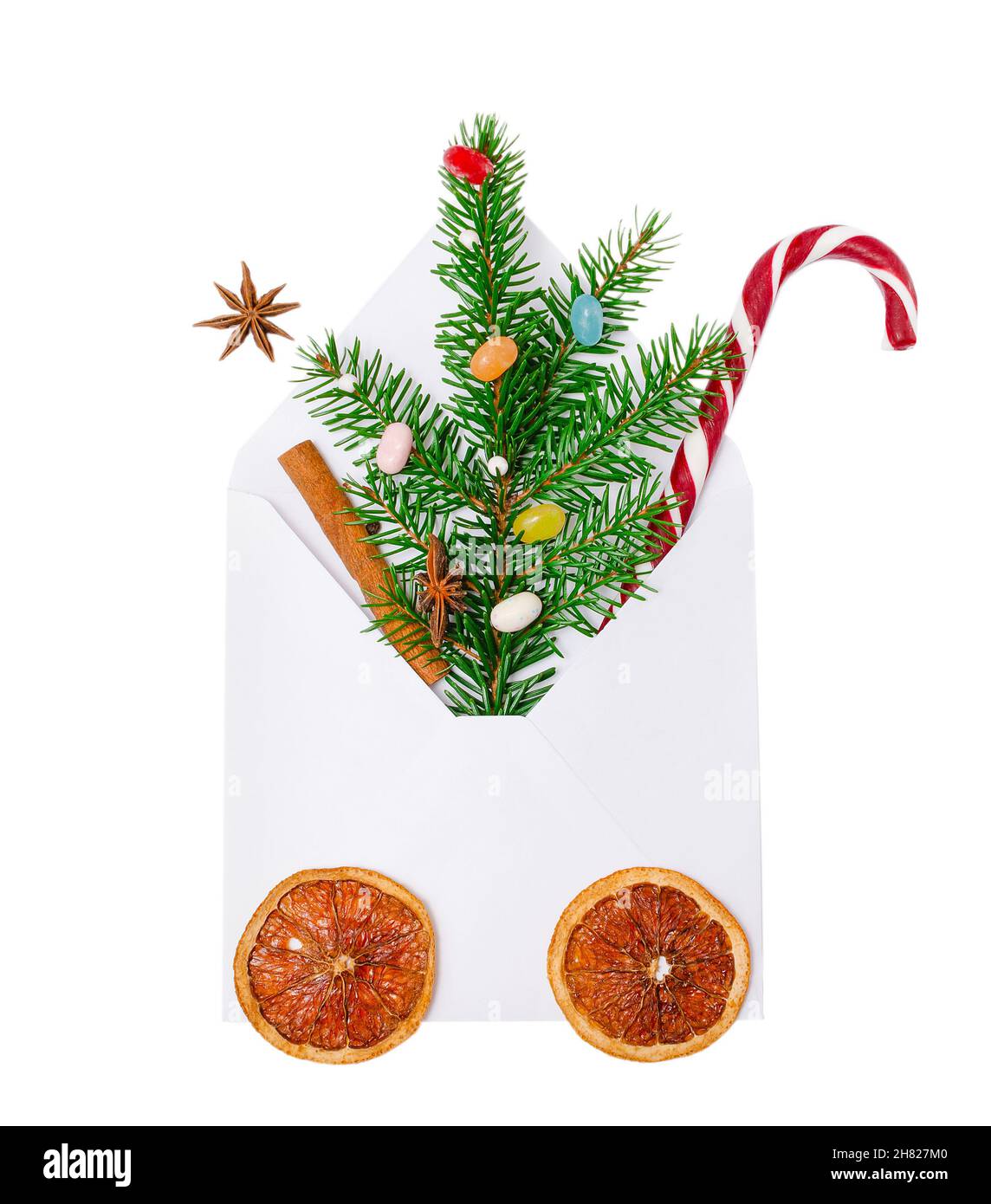 Weihnachtsumschlag mit Karamellrohr und grünem Fichtenzweig mit hellen Bonbons, Zimt und Anisstern. Weihnachtskonzept, Grußkarten, invitati Stockfoto