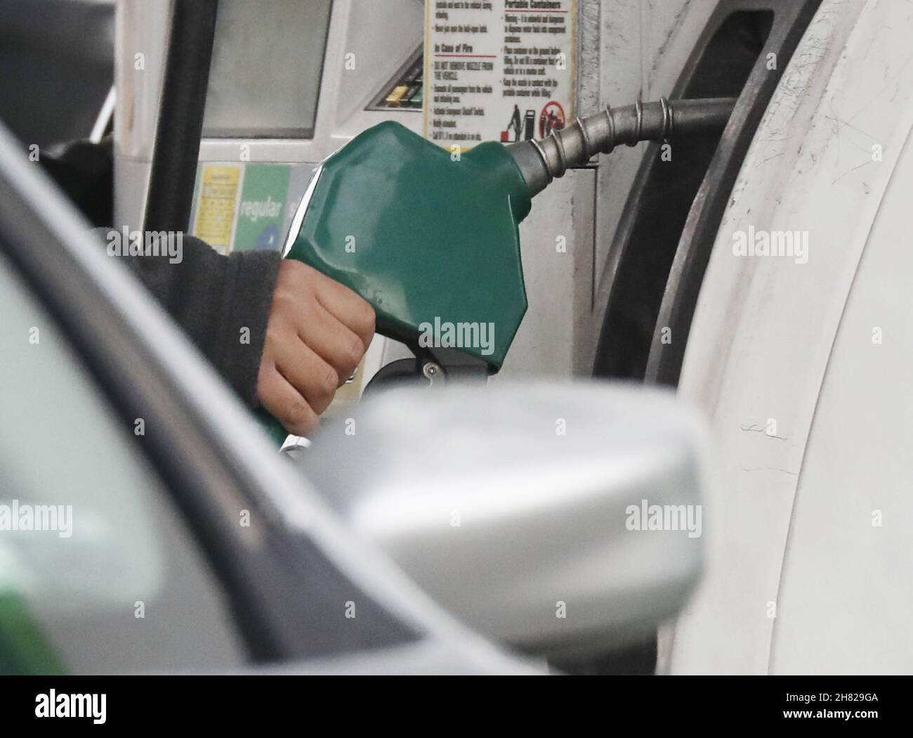 New York, USA. 26th. November 2021. Ein Arbeiter an einer Tankstelle steckt am Freitag, den 26. November 2021, Gas in das Auto eines Kunden in New York City. Die Ölpreise fielen insgesamt um über 10 %, da befürchtet wurde, dass eine mögliche neue COVID-19-Variante im südlichen Afrika entdeckt werden könnte. Foto von John Angelillo/UPI Credit: UPI/Alamy Live News Stockfoto