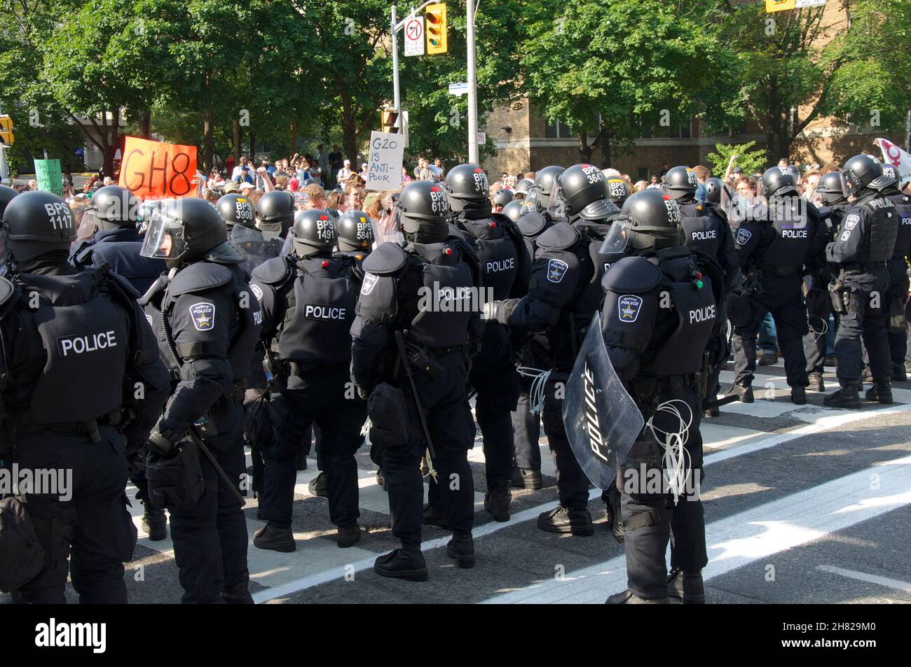 Toronto, Ontario, Kanada - 06/25/2010 : die Polizei von Riot ist voll im Gang, um Tausende von Aktivisten zu kontrollieren, die in einem Protest vor der Universität entlang marschieren Stockfoto