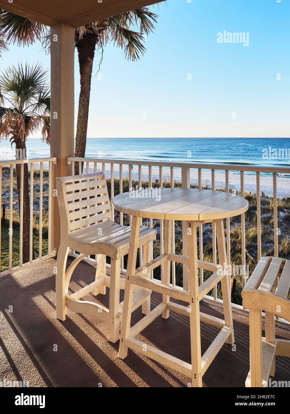 Tisch und Stühle auf einem Balkon mit Blick auf den Strand und das Meer oder den Golf von Mexiko in Florida, USA. Stockfoto