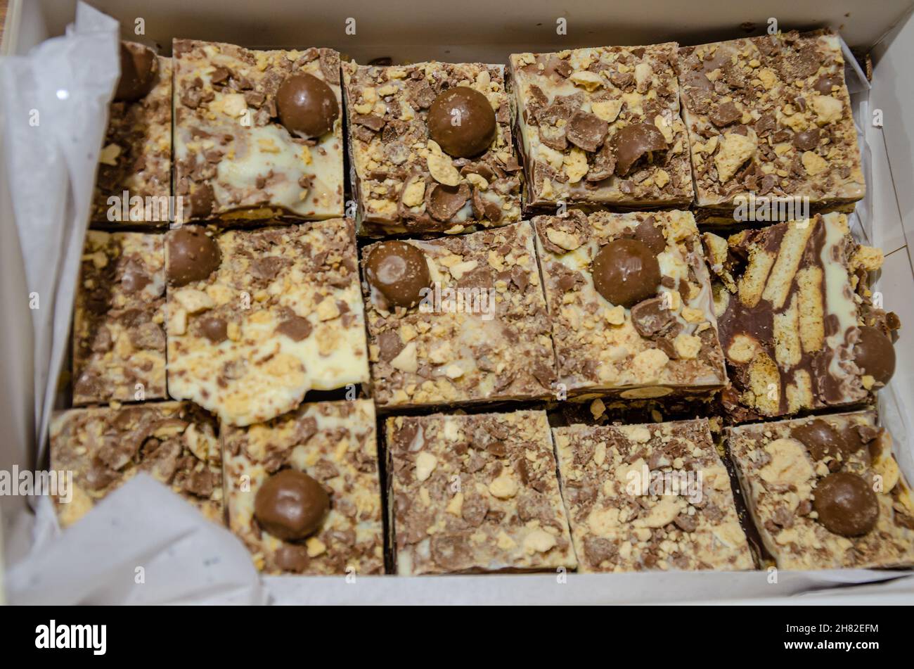 Eine Kiste mit Tiffin, ein Kuchen aus Schokolade und zerbrochenen Keksen Stockfoto