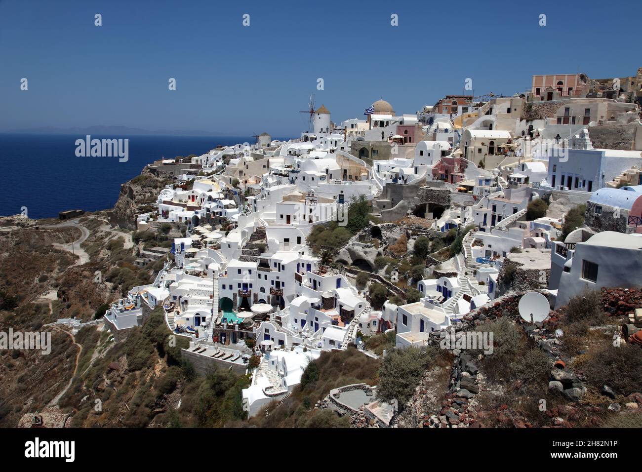 Oia Stadt und Windmühle auf der wunderschönen griechischen Insel Santorini in Griechenland. Oia ist eine kleine Stadt und ehemalige Gemeinde in der südlichen Ägäis auf Santorin. Stockfoto