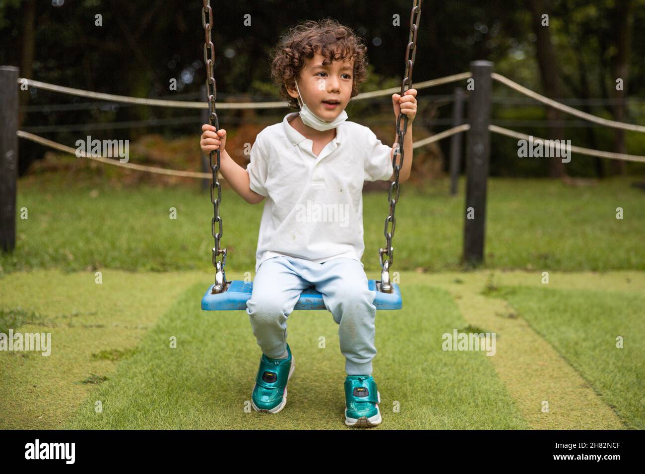 Kind auf einer Schaukel auf dem Spielplatz Stockfoto