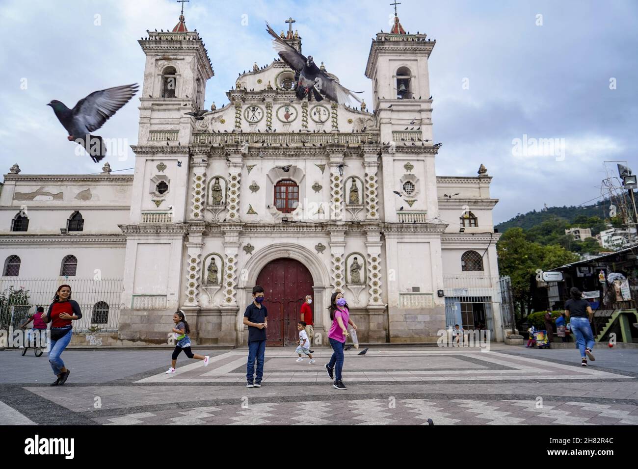 Tegucigalpa, Honduras. 26th. November 2021. Kinder füttern die Tauben vor einer Kirche.die Republik Honduras wird am 28th. November Parlamentswahlen abhalten, um eine neue Gruppe von Präsidenten-, Kongress- und Kommunalregierungen zu wählen. (Foto von Camilo Freedman/SOPA Images/Sipa USA) Quelle: SIPA USA/Alamy Live News Stockfoto