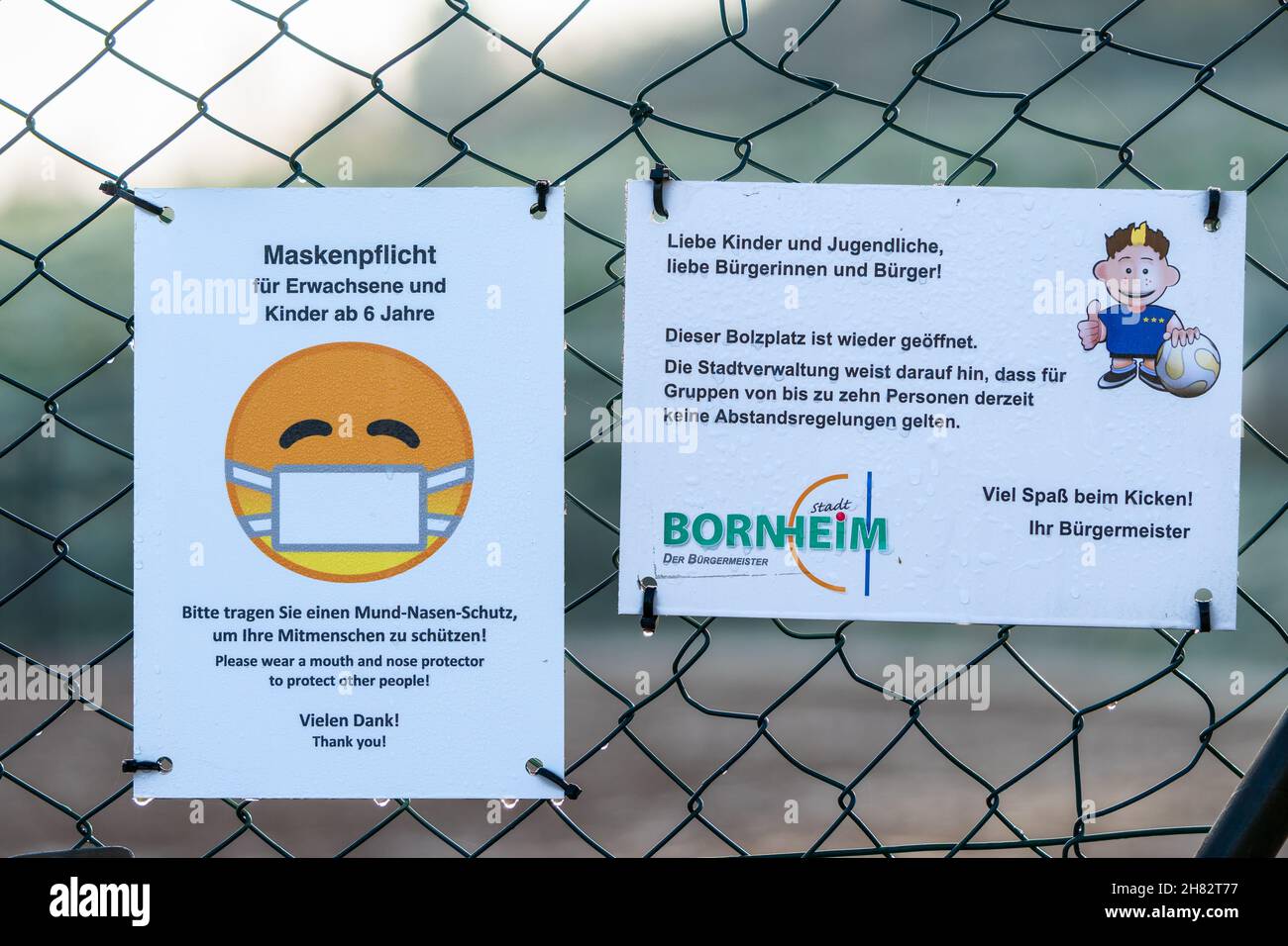 Bornheim, Deutschland - 10. Dezember 2020: Schilder am Kettengliederzaun mit deutschem Text "Fußballplatz ist wieder geöffnet. Keine Distanzierungsregeln für Gruppen von zehn Personen.“ Stockfoto