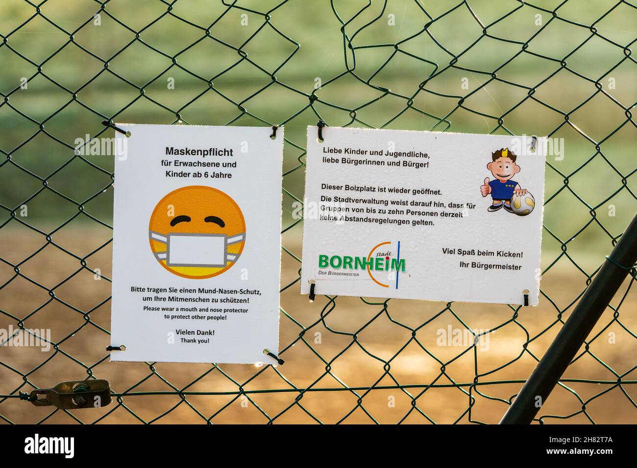 Bornheim, Deutschland - 10. Dezember 2020: Schilder am Kettengliederzaun mit deutschem Text "Fußballplatz ist wieder geöffnet. Keine Distanzierungsregeln für Gruppen von zehn Personen.“ Stockfoto