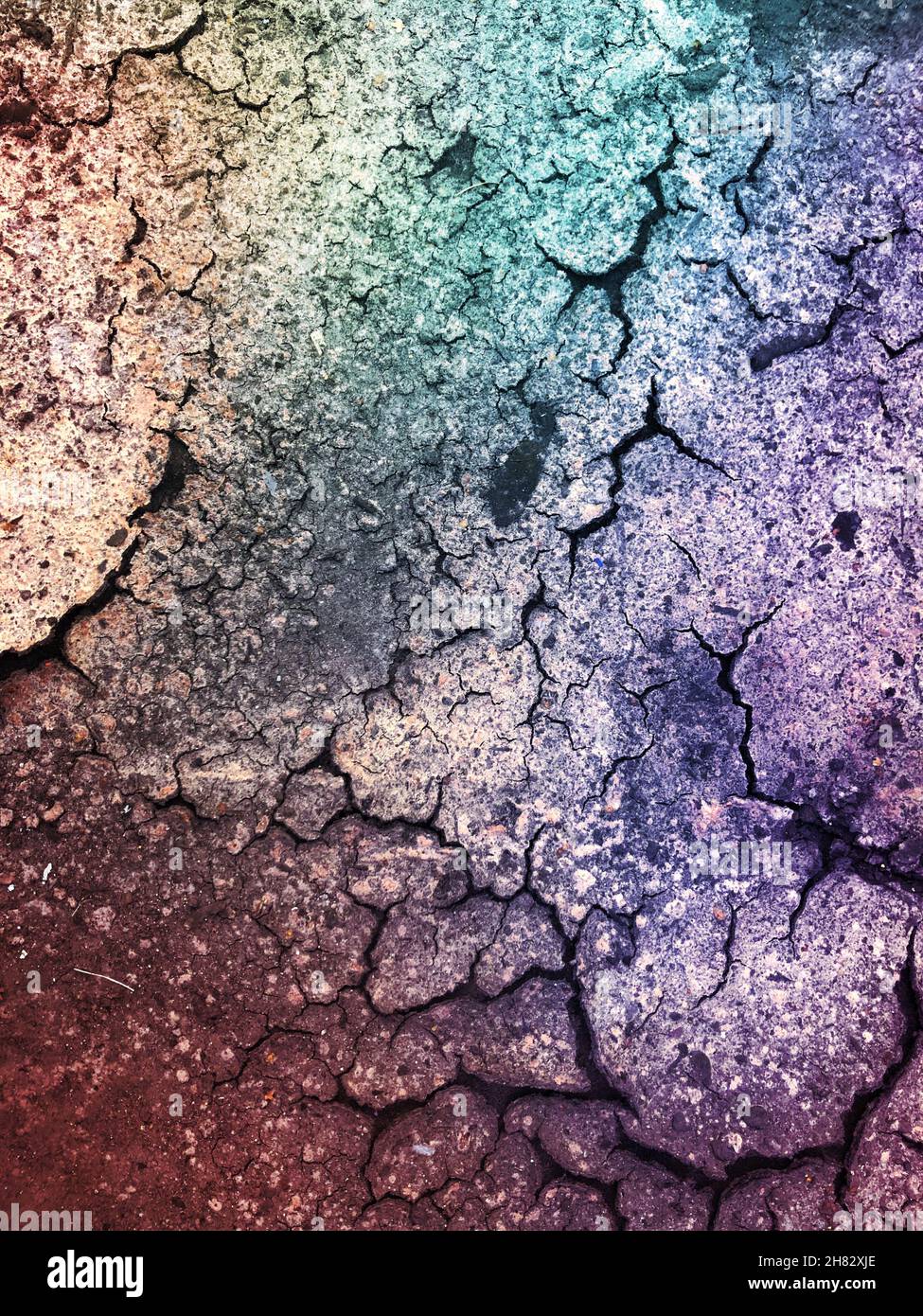 Grunge- oder Texturhintergrund von trockener und rissiger Oberfläche mit grünen und violetten farbigen Farbton und Kopierraum Stockfoto