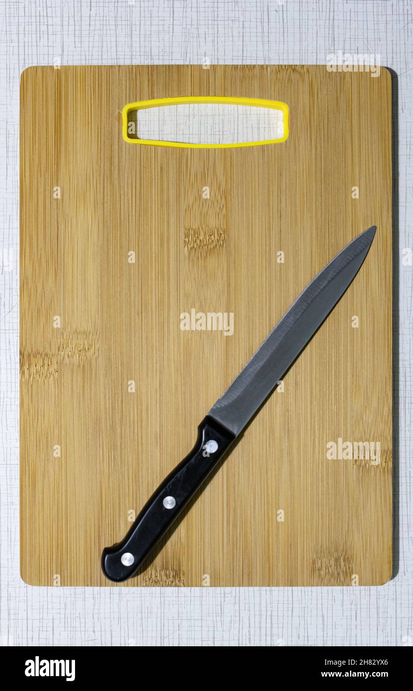 Ein scharfes Messer, das auf einem hölzernen Schneidbrett liegt. Hochwertige Fotos Stockfoto