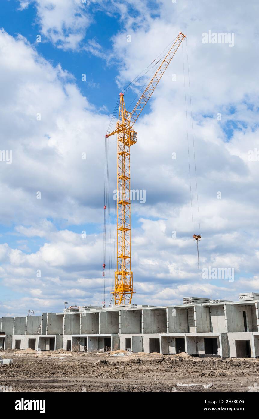 Hohe Kräne und Bau von Häusern Stockfoto