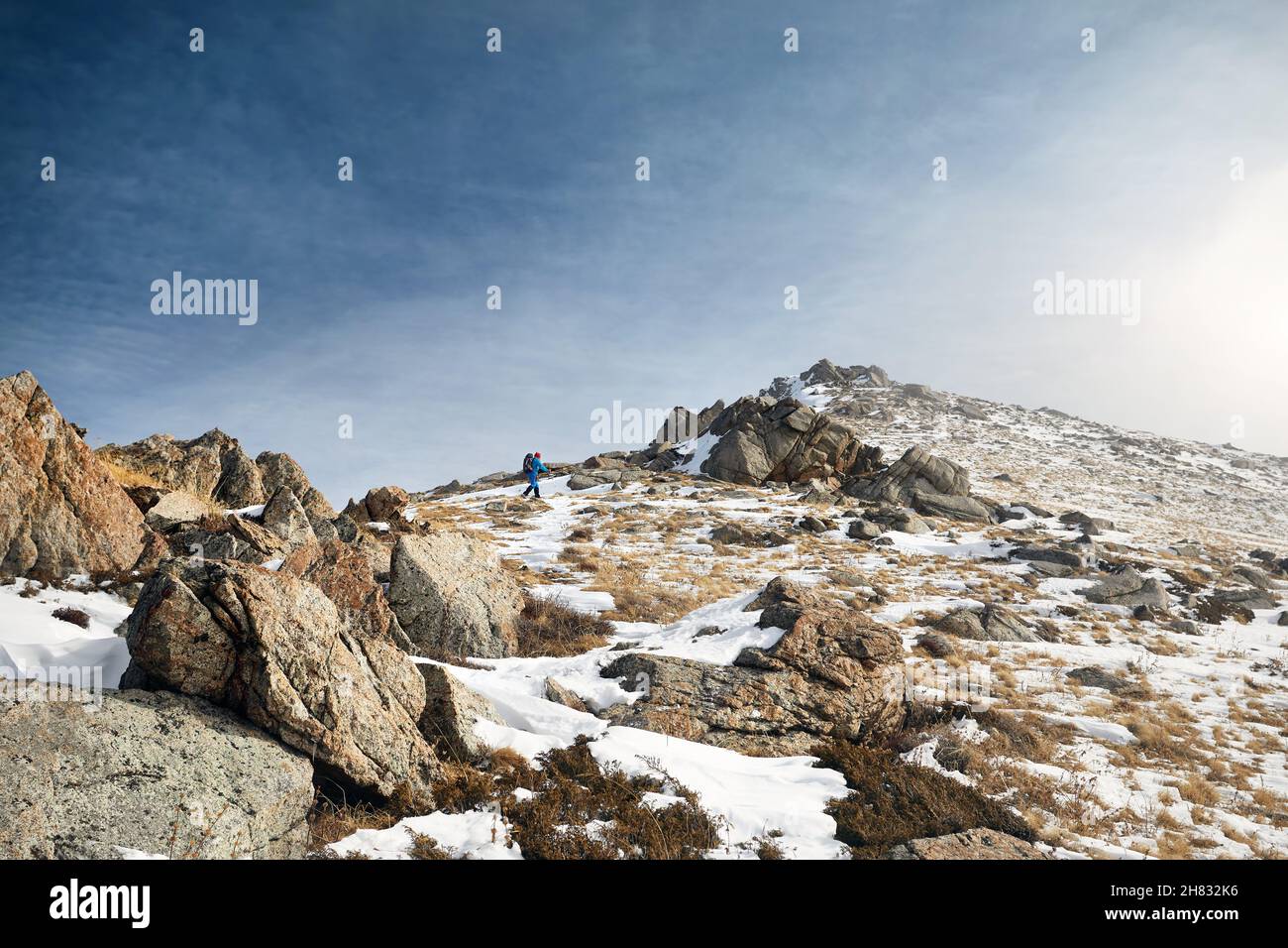 Mann mit Rucksack, der in der wunderschönen Berglandschaft bis zum Gipfel klettert Stockfoto