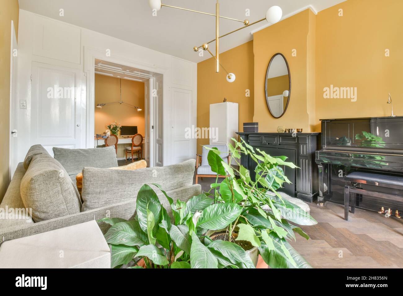 Geräumiges Wohnzimmer mit einem bequemen Sofa und gelben Wänden Stockfoto